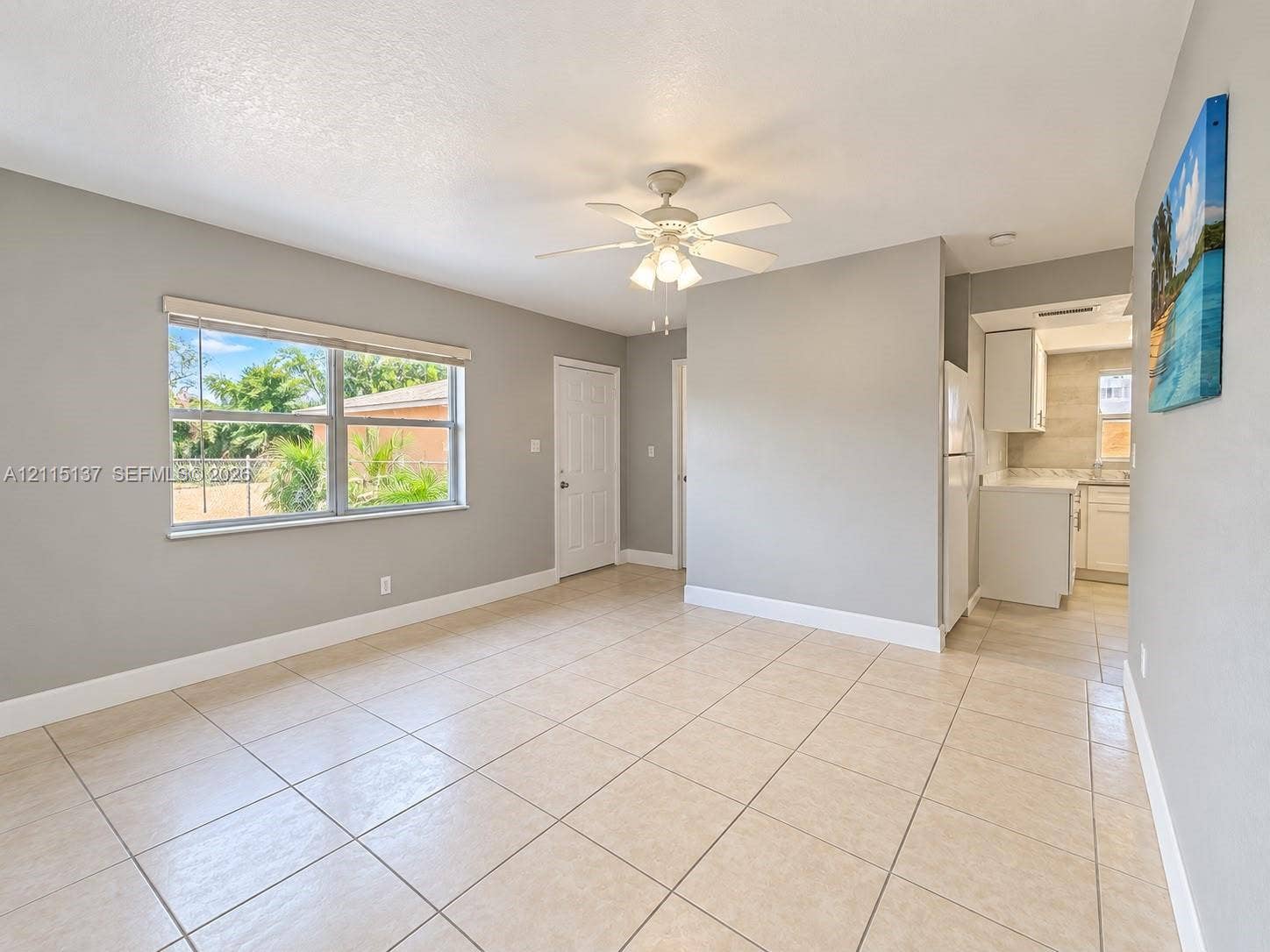 7870 SW 10th Court, #A, North Lauderdale, North Lauderdale, FL 33068 Interior space featuring neutral wall paint, tile flooring, a multi-blade ceiling fan with integrated light fixture, and a large window