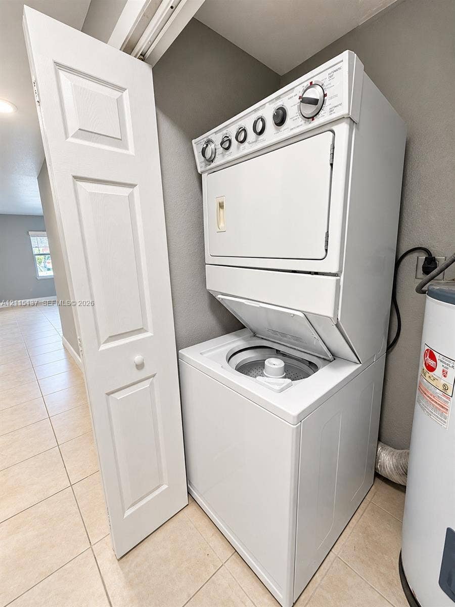 7870 SW 10th Court, #A, North Lauderdale, North Lauderdale, FL 33068 Stacked white laundry unit with top-loading washer, integrated dryer, and bi-fold closet door