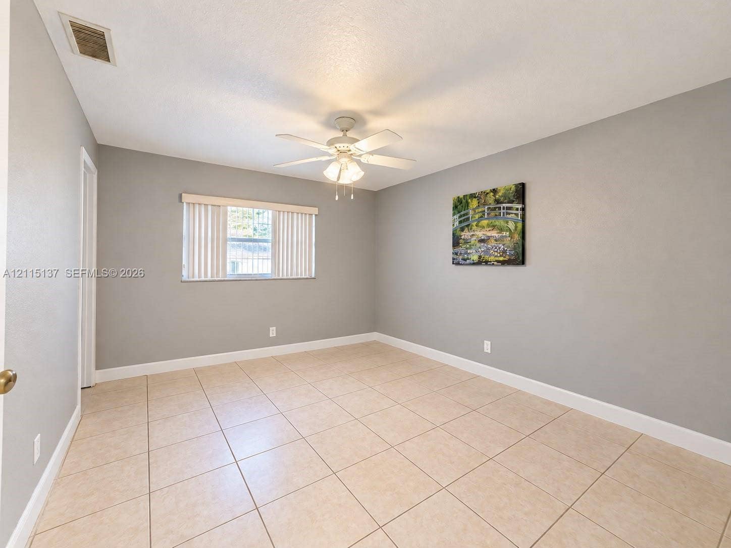 7870 SW 10th Court, #A, North Lauderdale, North Lauderdale, FL 33068 Interior room featuring large-format neutral floor tile, light grey wall paint, a multi-blade ceiling fan with an integrated light fixture, and a window with vertical blinds