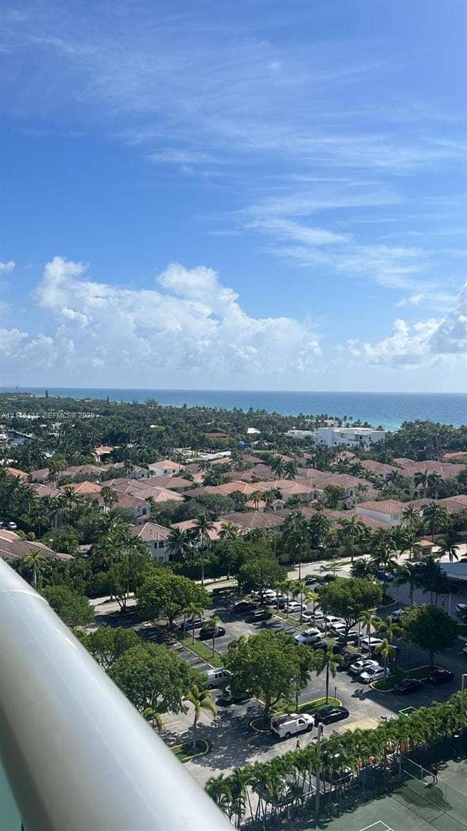 19380 Collins Avenue, #1602, Sunny Isles Beach, FL 33160 Elevated perspective featuring coastal horizon, mature tree canopy, and dedicated tennis court