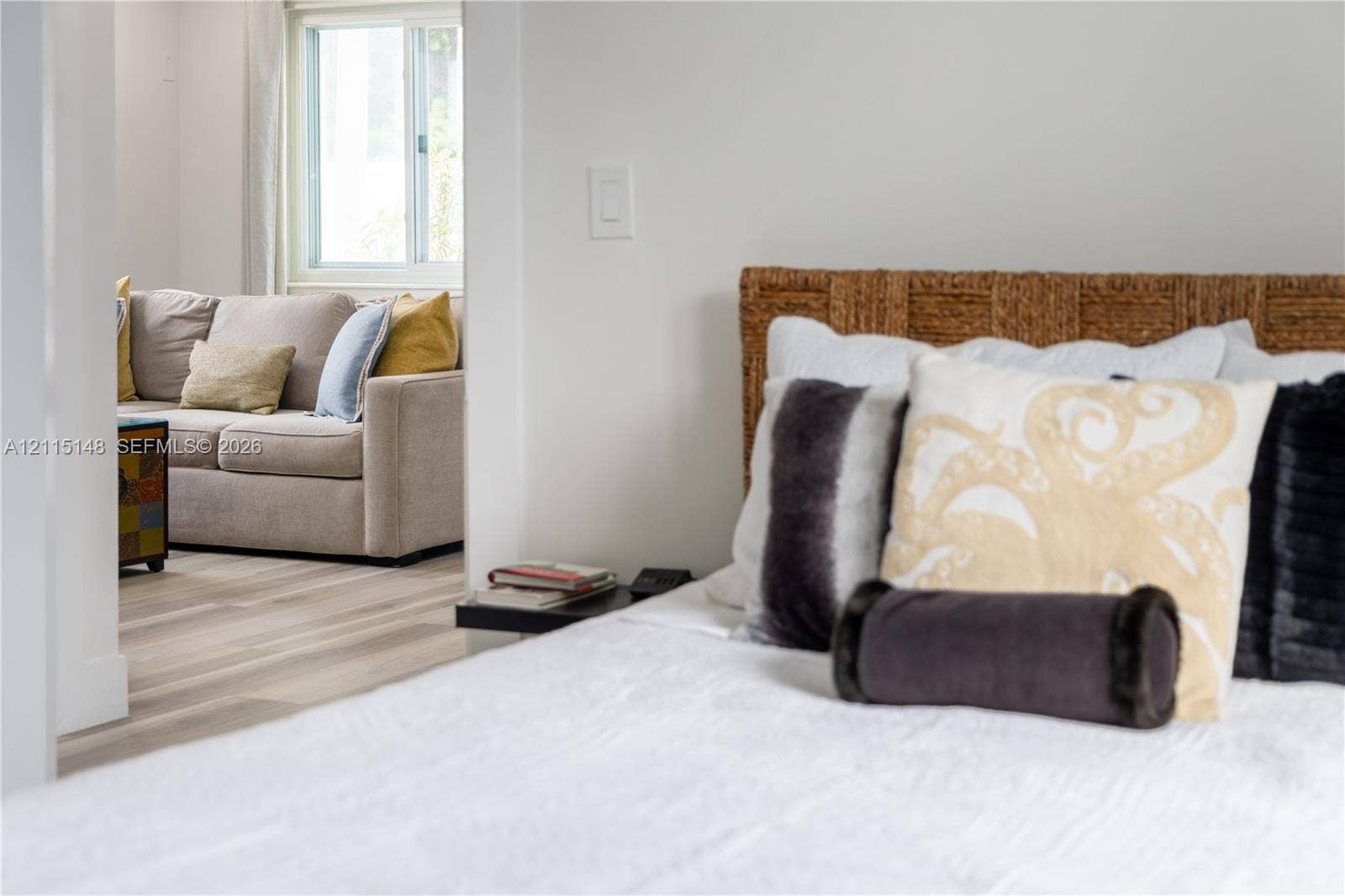 Neutral wall tones, light-finish wood flooring, and a sliding window