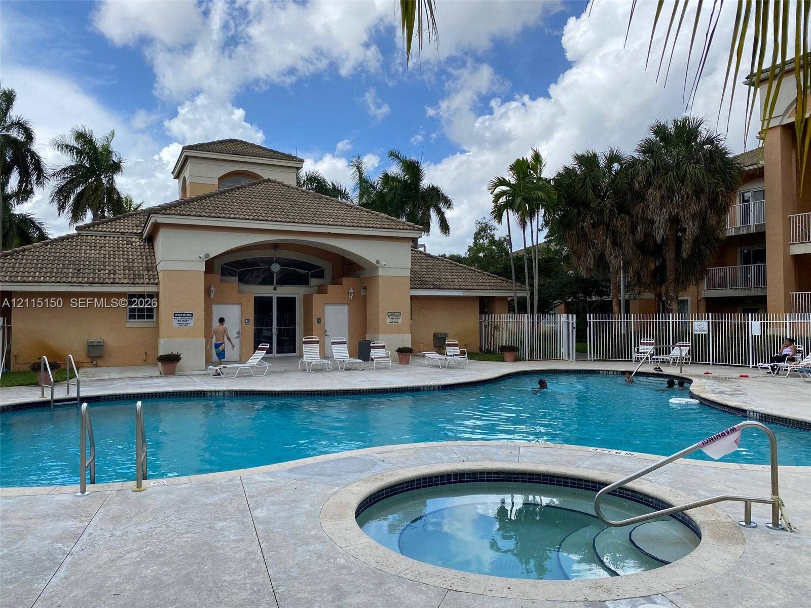 6992 SW 39th Street, #I201, Davie, Davie, FL 33314 Community swimming pool featuring a concrete deck, built-in hot tub, and tile-roof clubhouse