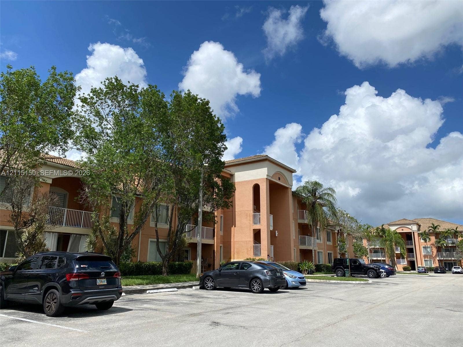 6992 SW 39th Street, #I201, Davie, Davie, FL 33314 Multi-story stucco exterior featuring arched architectural detailing, private balconies with metal railings, and a tile roof