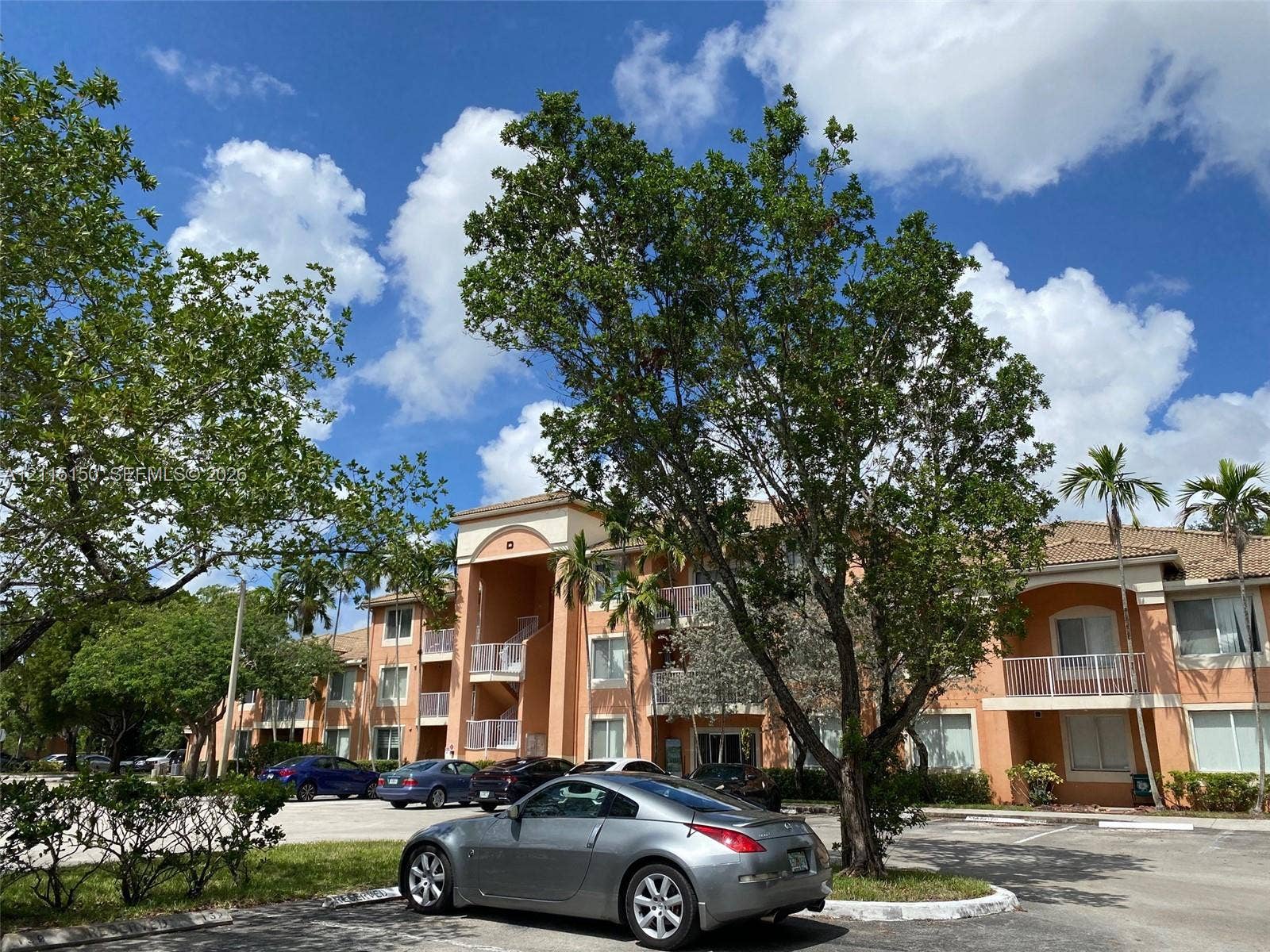 6992 SW 39th Street, #I201, Davie, Davie, FL 33314 Multi-story building exterior featuring stucco siding, arched entryways, and private balconies with white railings