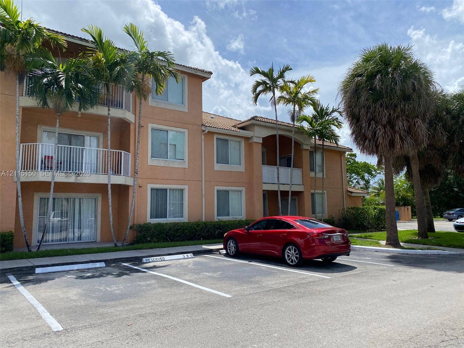 6992 SW 39th Street, #I201, Davie, Davie, FL 33314 Multi-level exterior featuring stucco siding, tiled roof, private balconies with metal railings, and reserved parking spaces