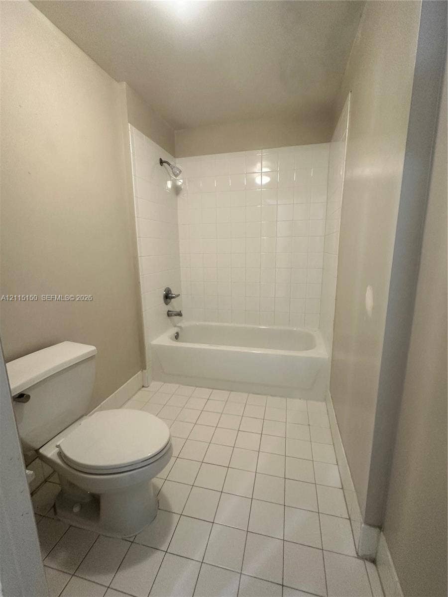 6992 SW 39th Street, #I201, Davie, Davie, FL 33314 Bathroom featuring a white ceramic tile floor, bathtub with a white tile surround, wall-mounted shower head, and dual-handle plumbing fixture