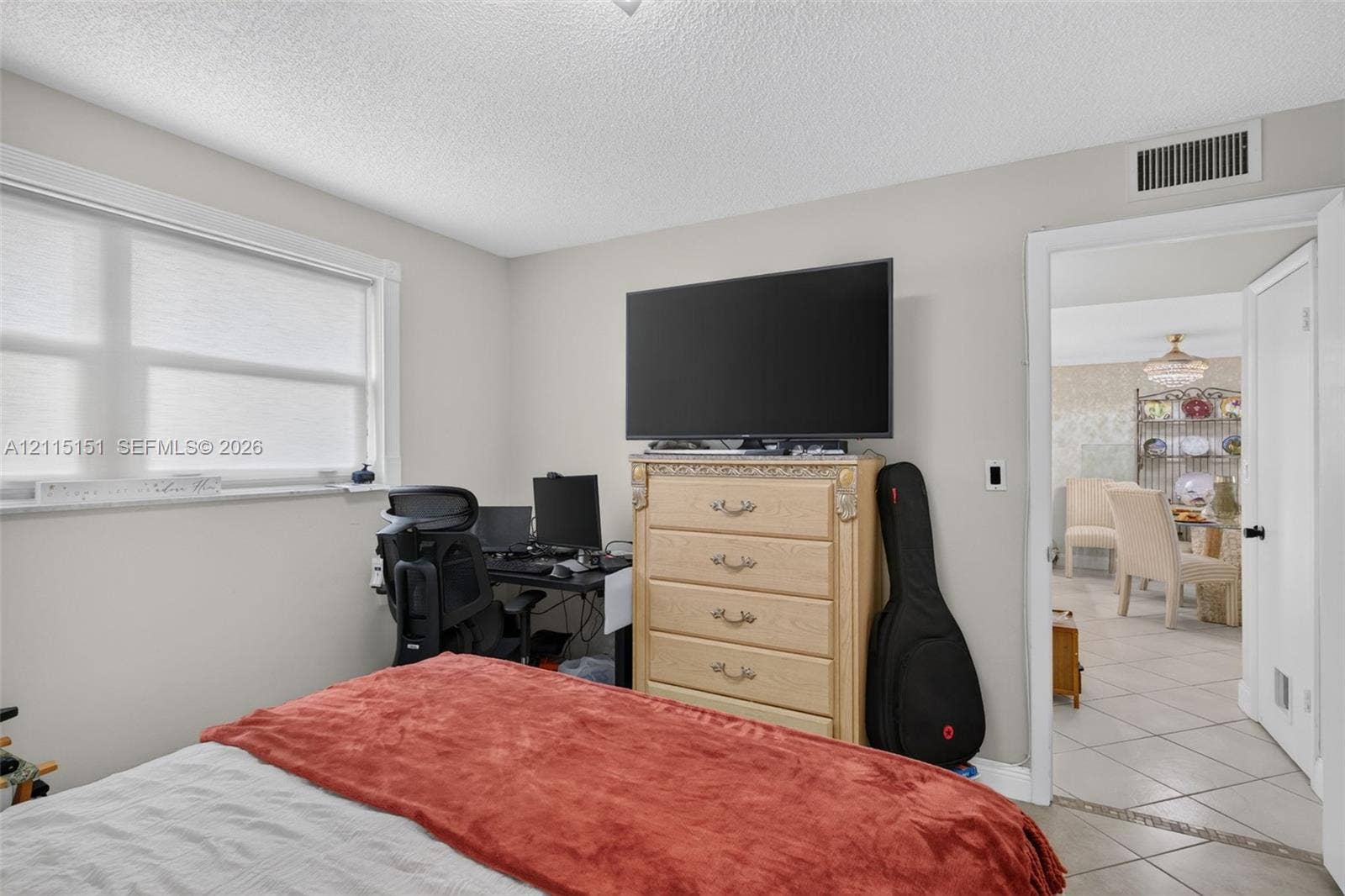 5951 NE 14th Lane, #408N, Fort Lauderdale, FL 33334 Neutral-toned bedroom featuring a large window with white frame and a solid-core interior door