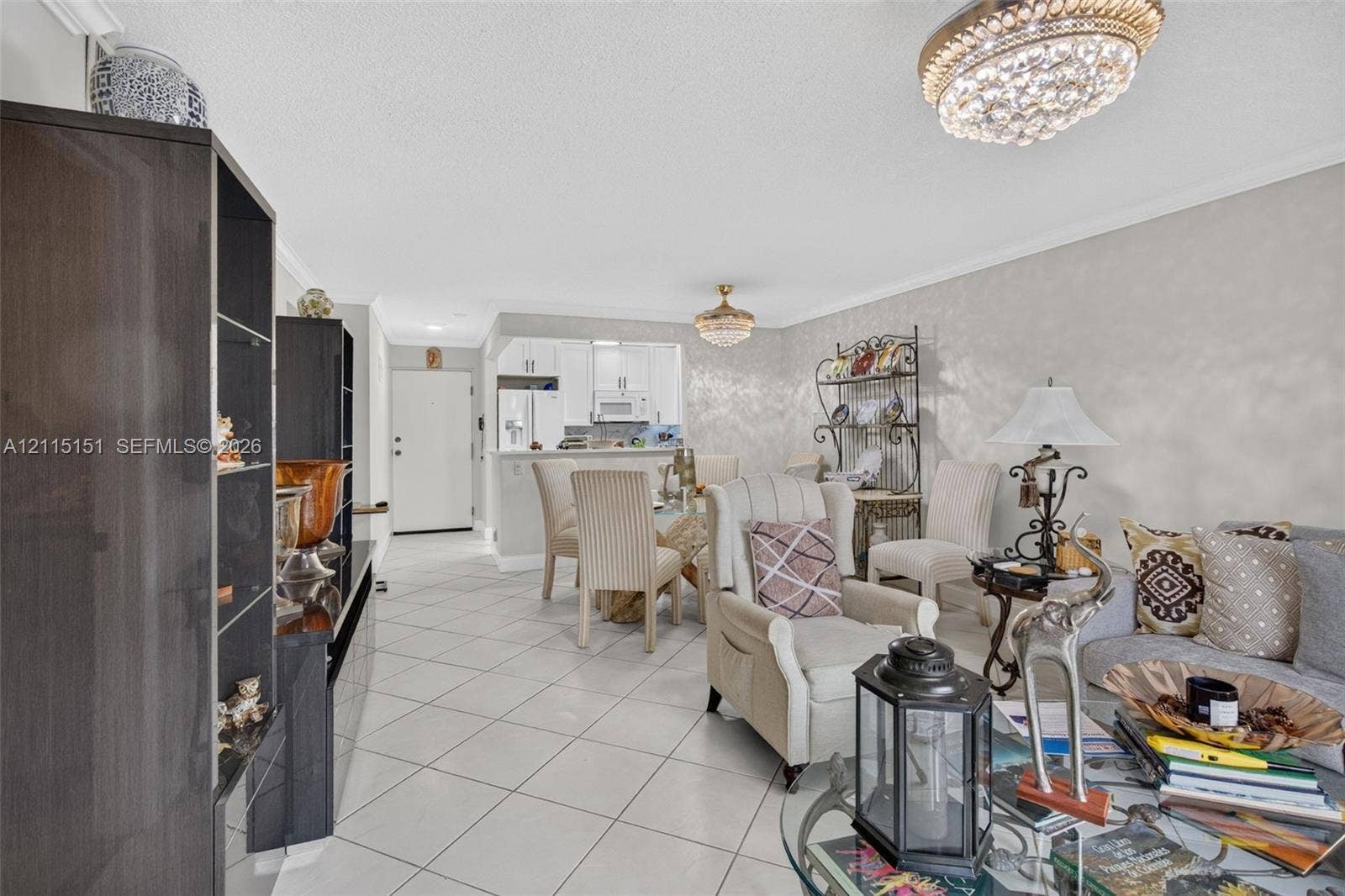 5951 NE 14th Lane, #408N, Fort Lauderdale, FL 33334 Open-concept interior featuring light-colored tile flooring, decorative crystal flush-mount lighting, and neutral wall tones
