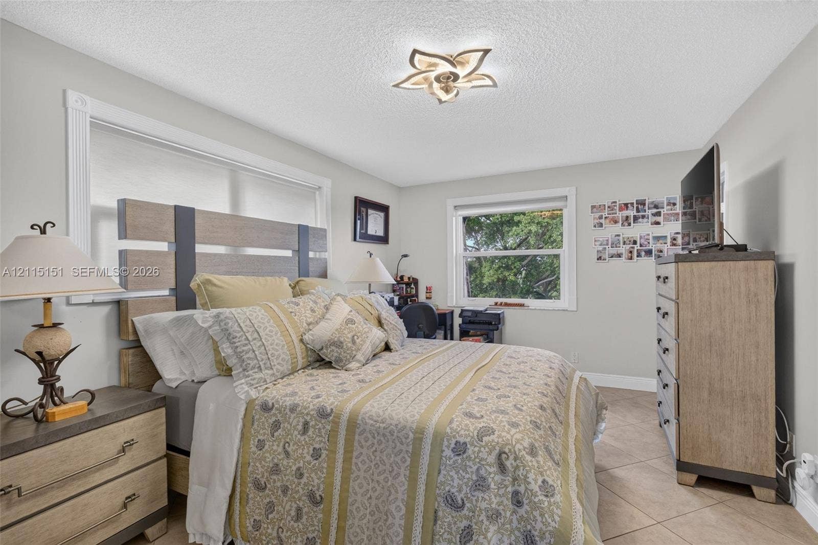 5951 NE 14th Lane, #408N, Fort Lauderdale, FL 33334 Neutral-toned interior featuring ceramic tile flooring, two windows with white casings, and a multi-petal style flush-mount ceiling light