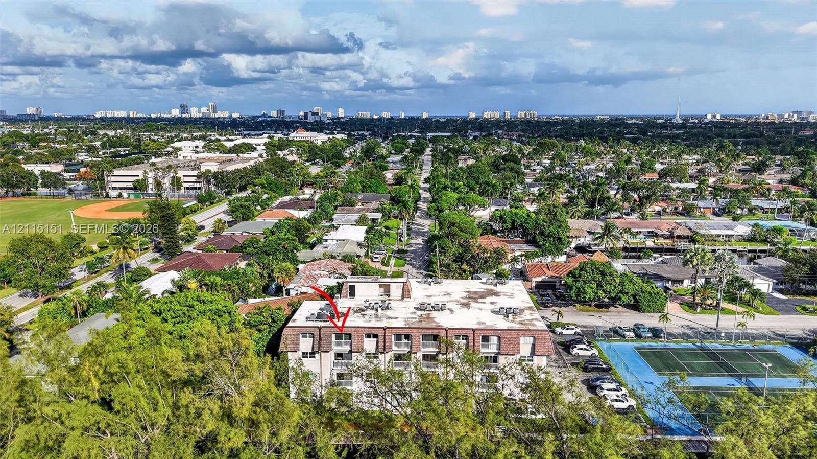 5951 NE 14th Lane, #408N, Fort Lauderdale, FL 33334 Aerial perspective of a multi-story residential building featuring private balconies, a mansard-style roof, and exterior parking