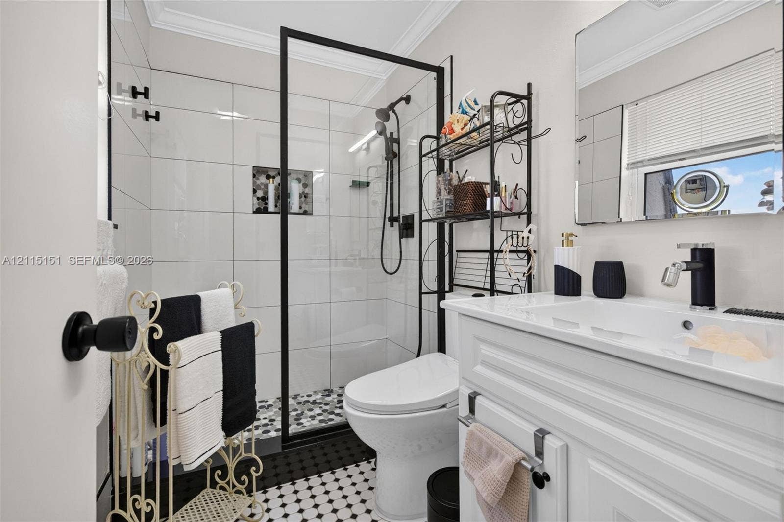 5951 NE 14th Lane, #408N, Fort Lauderdale, FL 33334 Full bathroom featuring a glass-enclosed shower with matte black fixtures, white subway wall tile, a built-in recessed niche, and a patterned tile floor