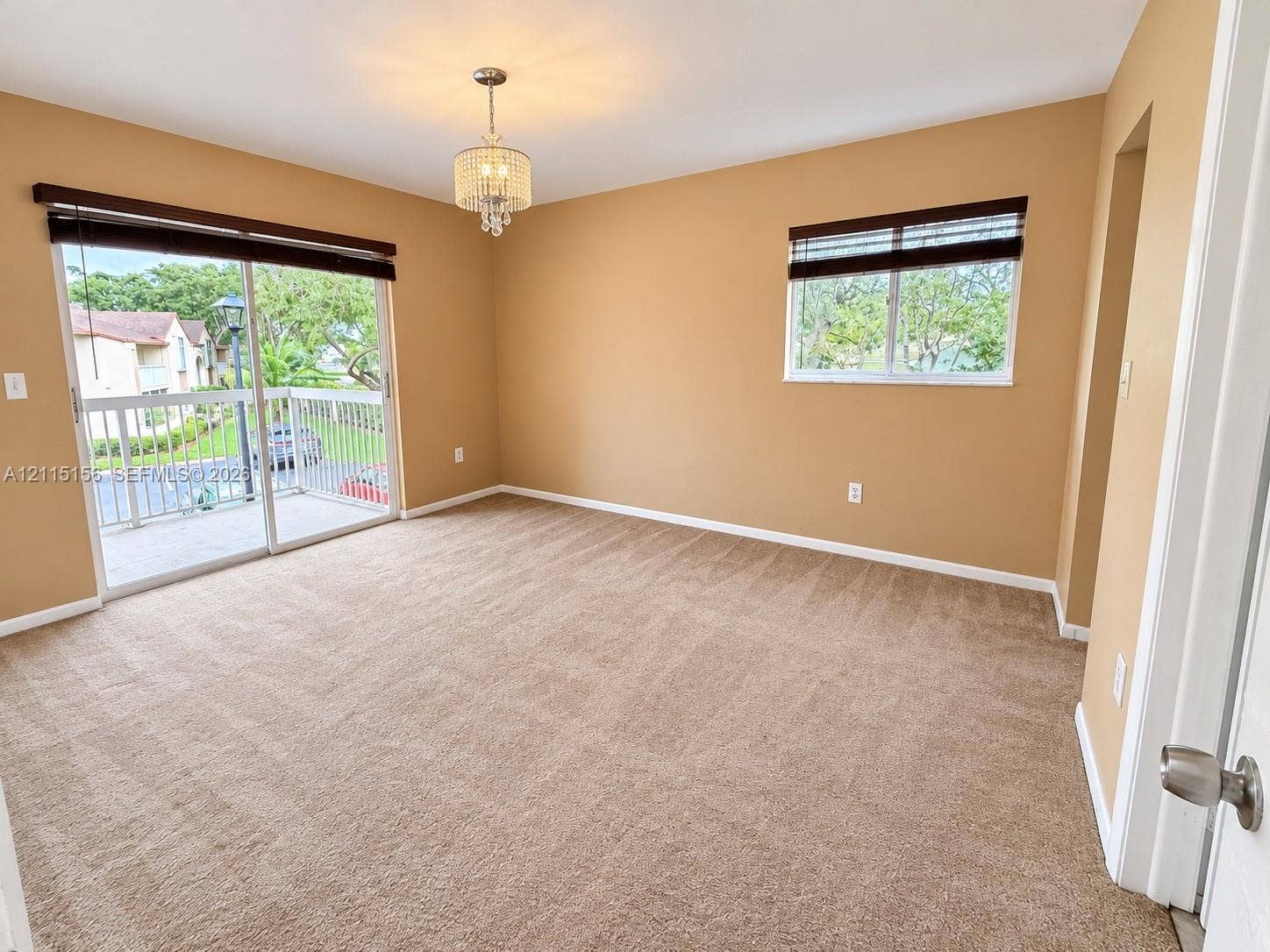 4800 NW 102nd Avenue, #201-10, Doral, Doral, FL 33178 Room featuring wall-to-wall carpeting, a crystal-style chandelier, sliding glass doors to a balcony, and window treatments