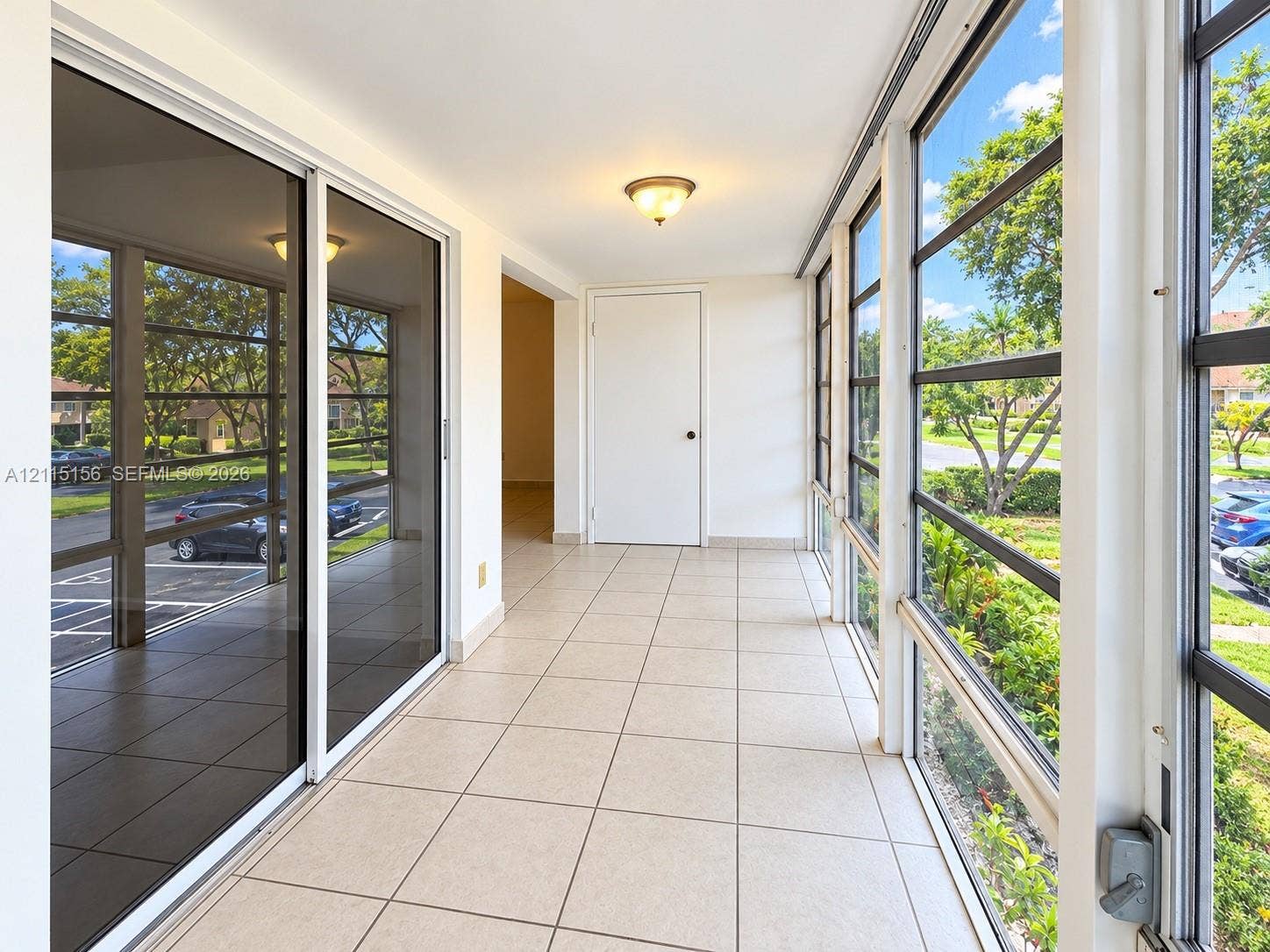 4800 NW 102nd Avenue, #201-10, Doral, Doral, FL 33178 Enclosed patio featuring floor-to-ceiling screened windows, large-format tile flooring, sliding glass door entry, and flush-mount lighting