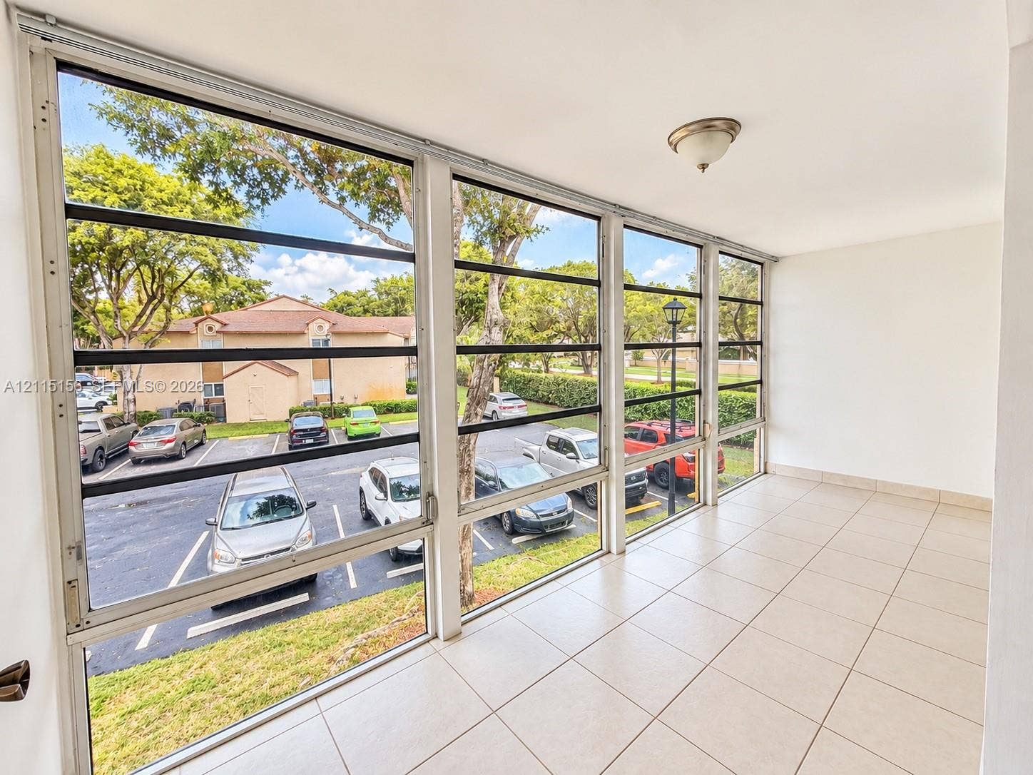 4800 NW 102nd Avenue, #201-10, Doral, Doral, FL 33178 Enclosed balcony featuring light-toned tile flooring, floor-to-ceiling windows, and a flush-mount ceiling light fixture