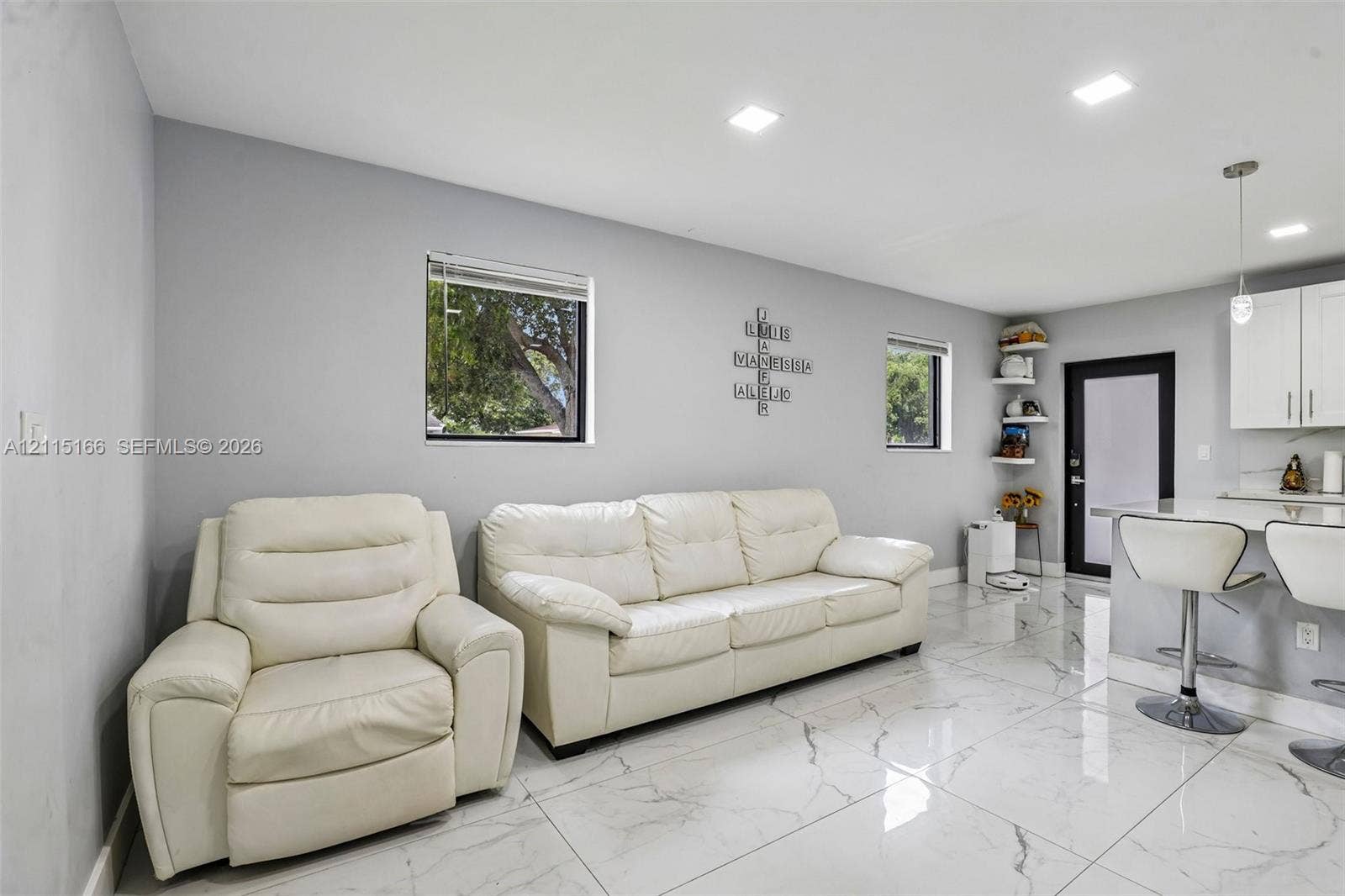 1421 N 68th Terrace, Hollywood, FL 33024 Large-format stone-finish floor tiling, recessed ceiling lighting, custom white cabinetry, and built-in corner shelving