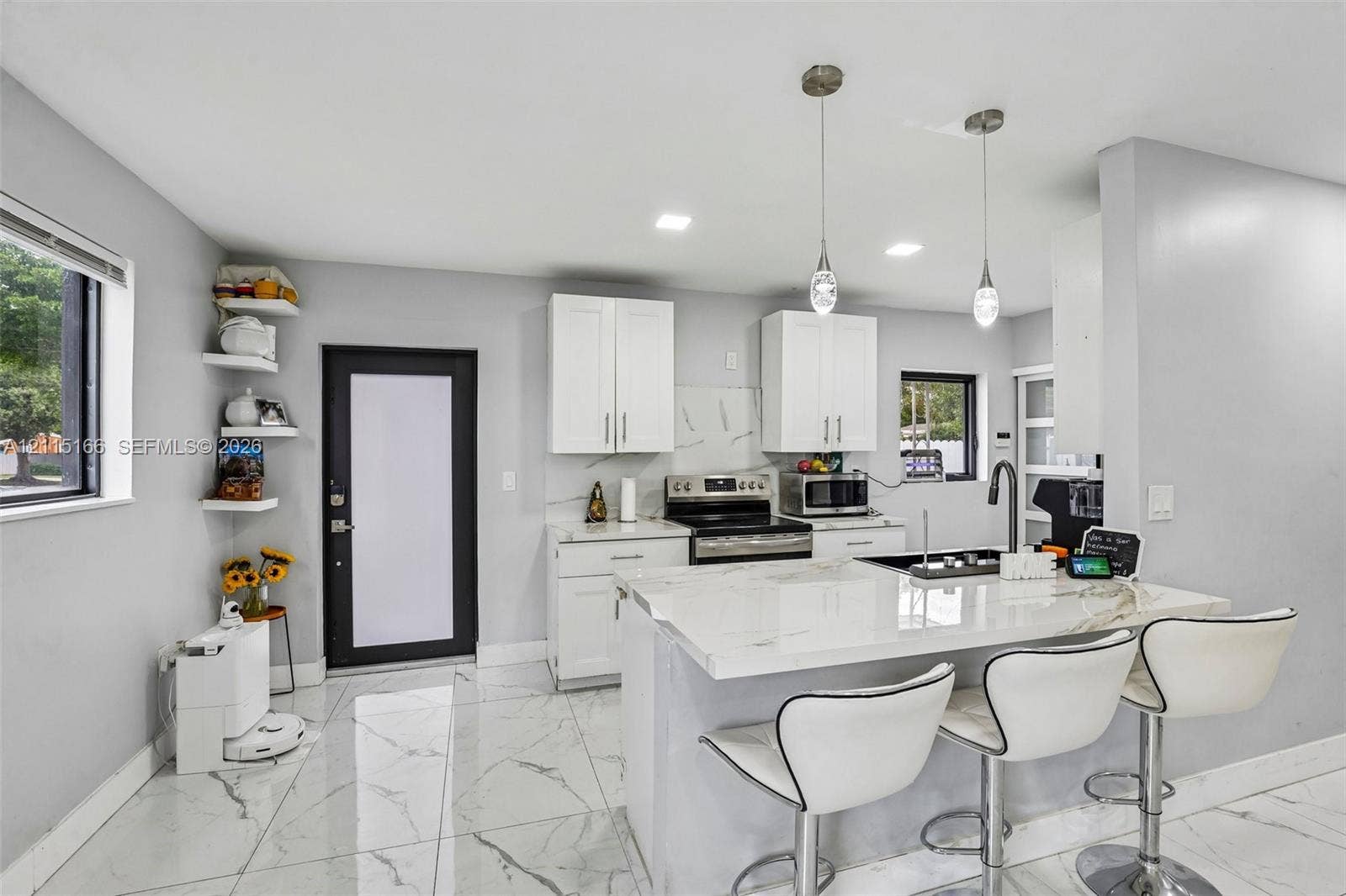 1421 N 68th Terrace, Hollywood, FL 33024 Kitchen featuring white cabinetry, stone-finish countertops, tile flooring, built-in shelving, and dual pendant lighting