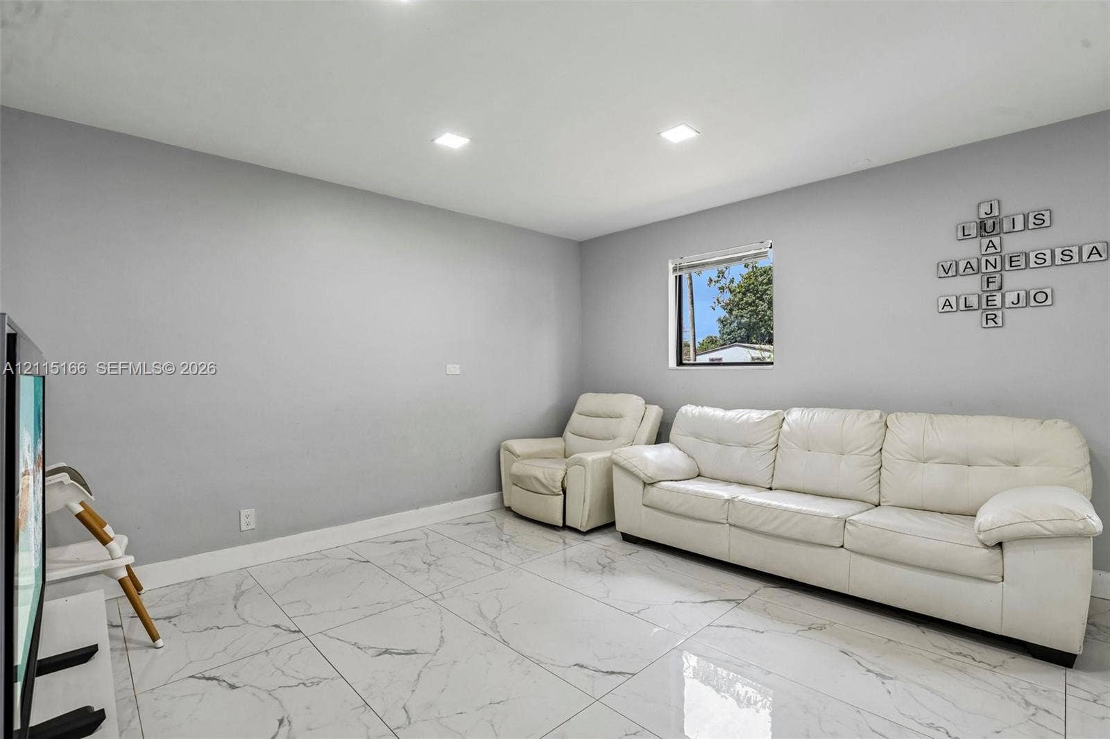 1421 N 68th Terrace, Hollywood, FL 33024 Neutral-toned interior featuring large-format tile flooring, recessed lighting, and a single-pane window