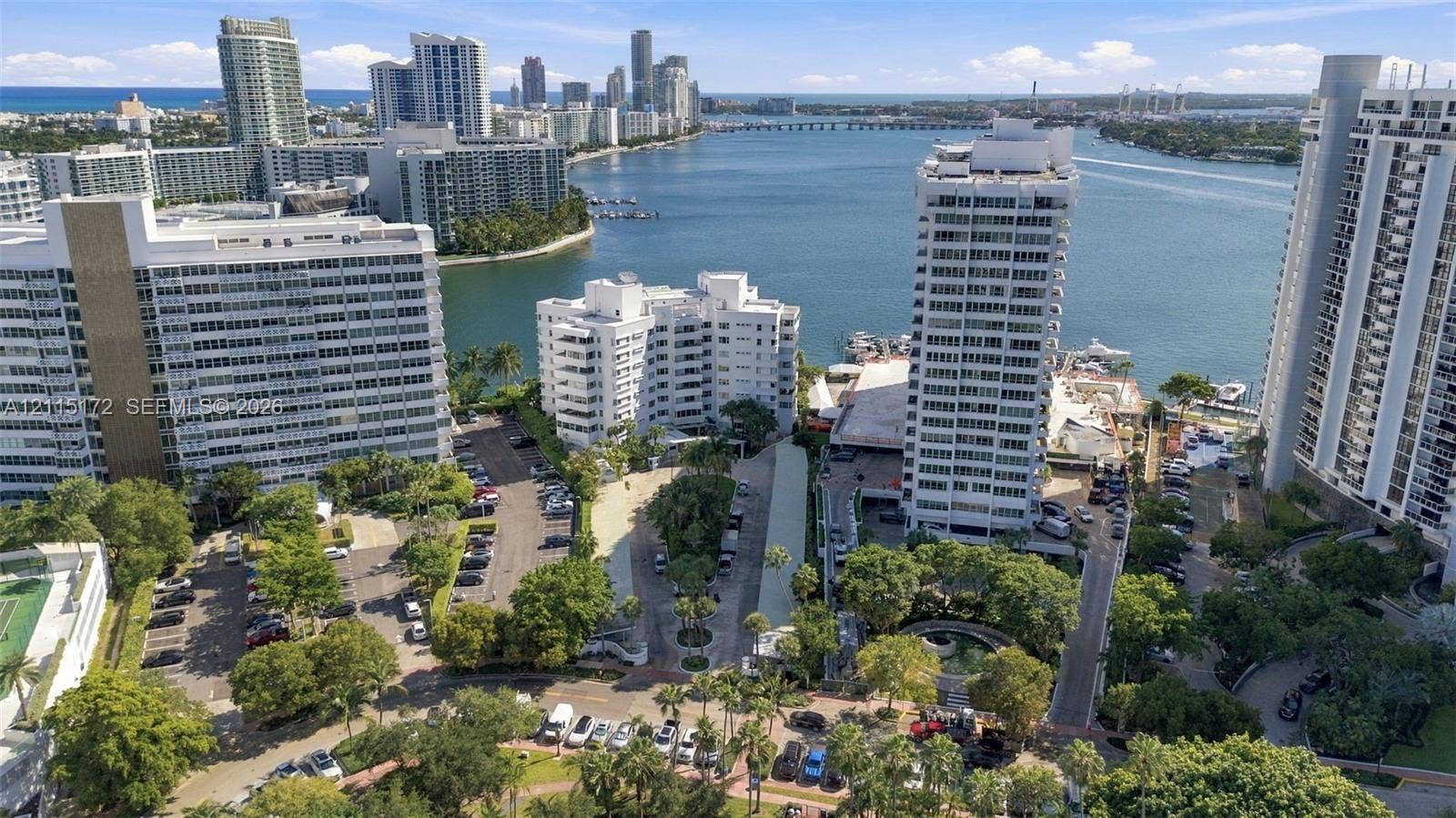 16 Island Avenue, #5C, Miami Beach, FL 33139 Aerial perspective of high-rise structures featuring water frontage, established landscaping, paved parking areas, and proximity to a coastal waterway