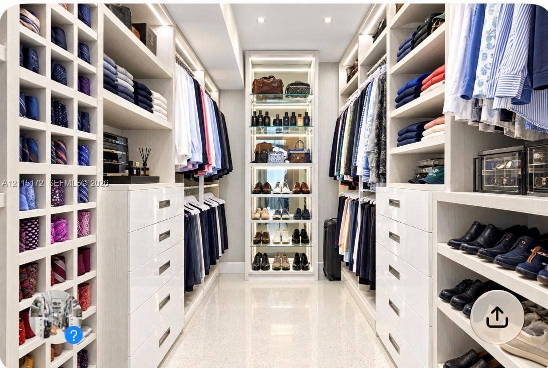 16 Island Avenue, #5C, Miami Beach, FL 33139 Custom dressing area featuring extensive white built-in cabinetry, floor-to-ceiling storage cubbies, integrated accent lighting, and polished stone flooring