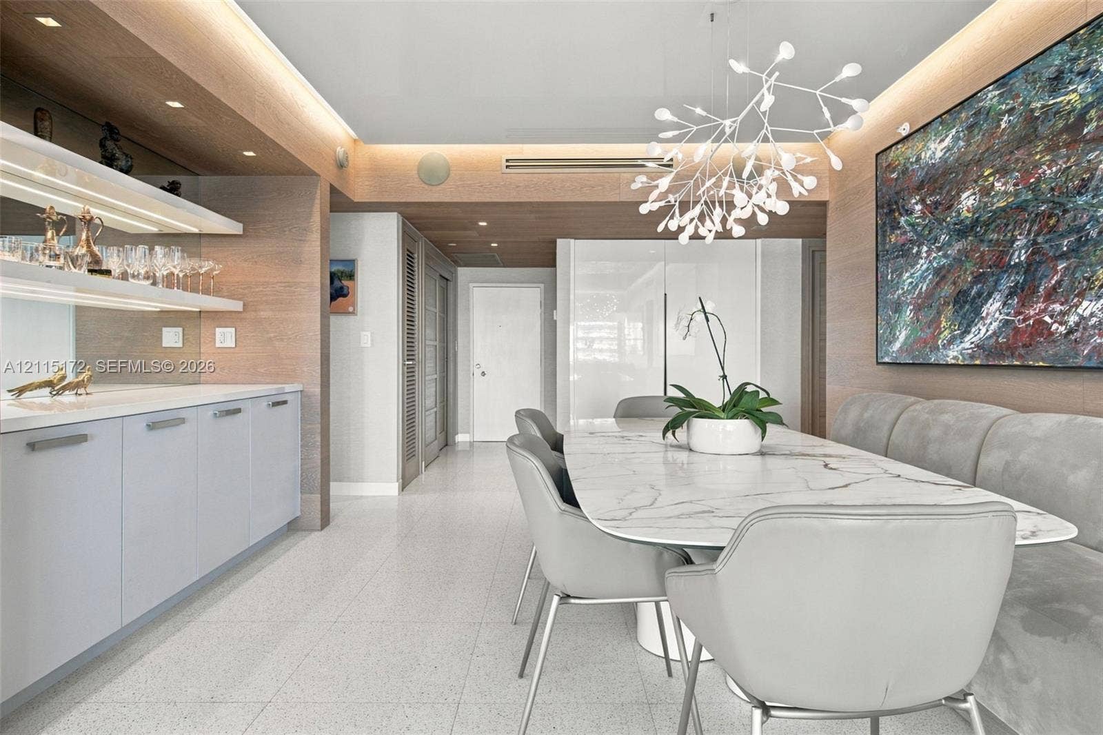 16 Island Avenue, #5C, Miami Beach, FL 33139 Built-in wet bar with illuminated shelving, integrated cabinetry, wood-finish wall paneling, ceiling recessed lighting, and a modern sculptural pendant fixture