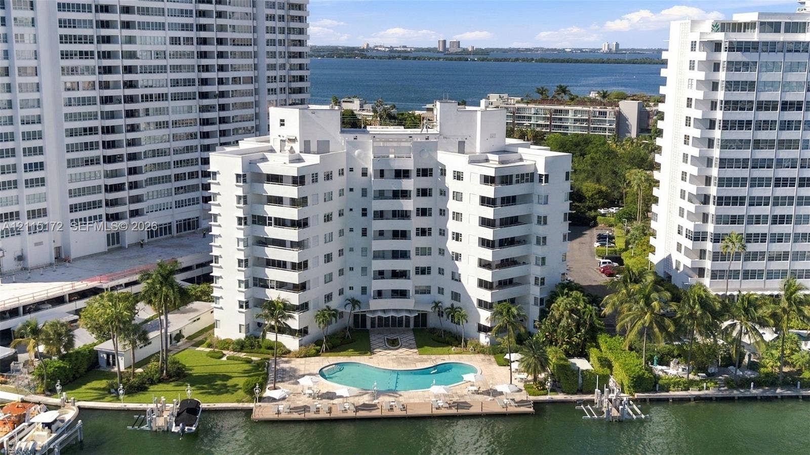 16 Island Avenue, #5C, Miami Beach, FL 33139 Multi-story residential building featuring private waterfront access, an outdoor swimming pool, a concrete pool deck, and manicured landscaping