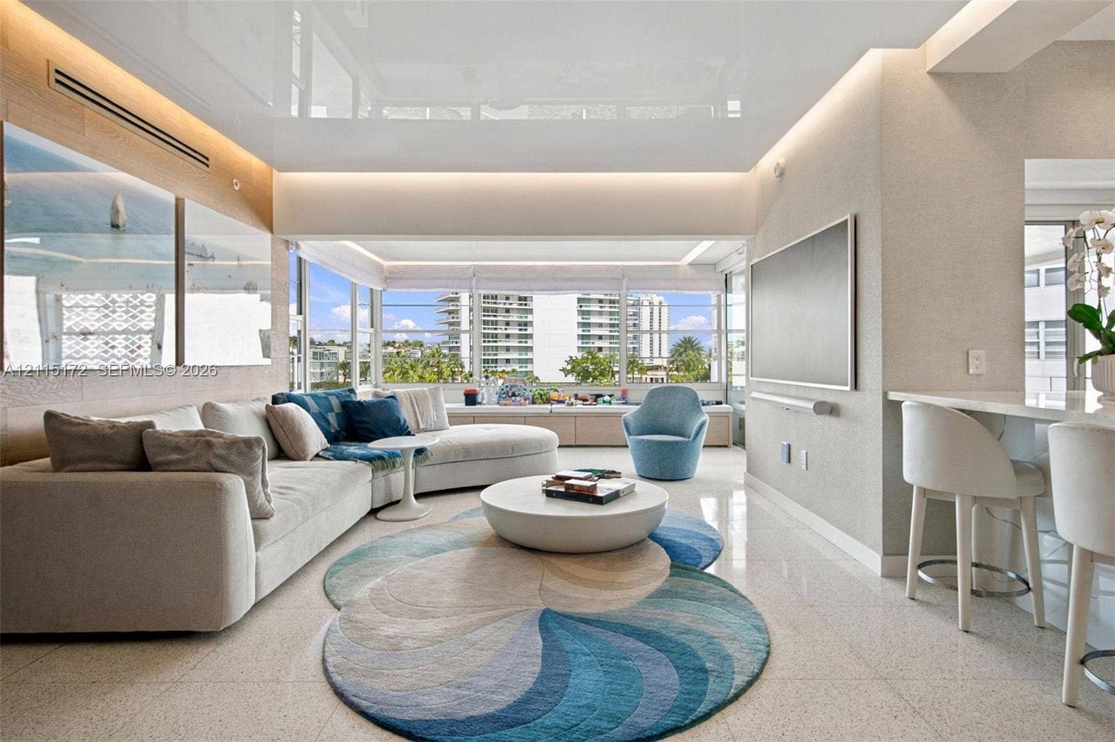16 Island Avenue, #5C, Miami Beach, FL 33139 High-gloss finish ceiling with recessed accent lighting, expansive floor-to-ceiling windows, polished stone flooring, and custom built-in cabinetry