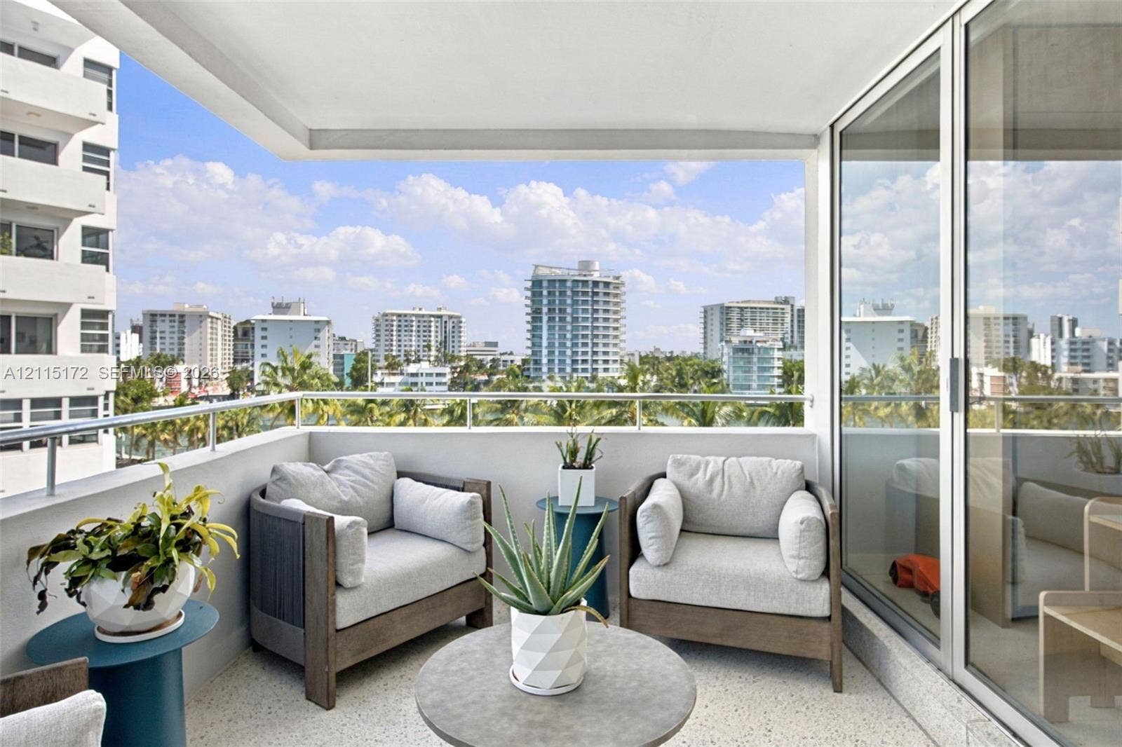 16 Island Avenue, #5C, Miami Beach, FL 33139 Covered balcony featuring a metal railing and terrazzo flooring, offering an expansive outlook of the surrounding cityscape