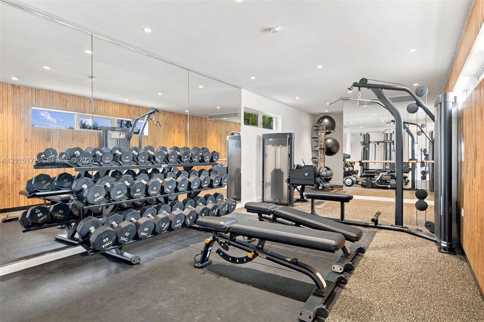 16 Island Avenue, #5C, Miami Beach, FL 33139 Full-wall mirrors, wood-paneled walls, recessed ceiling lighting, and textured flooring
