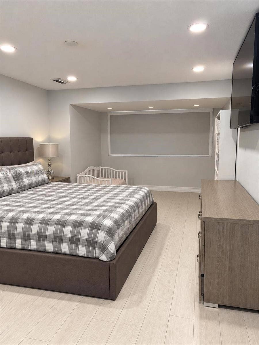 Neutral color palette featuring light-toned wood-finish flooring, recessed lighting, and a recessed window nook