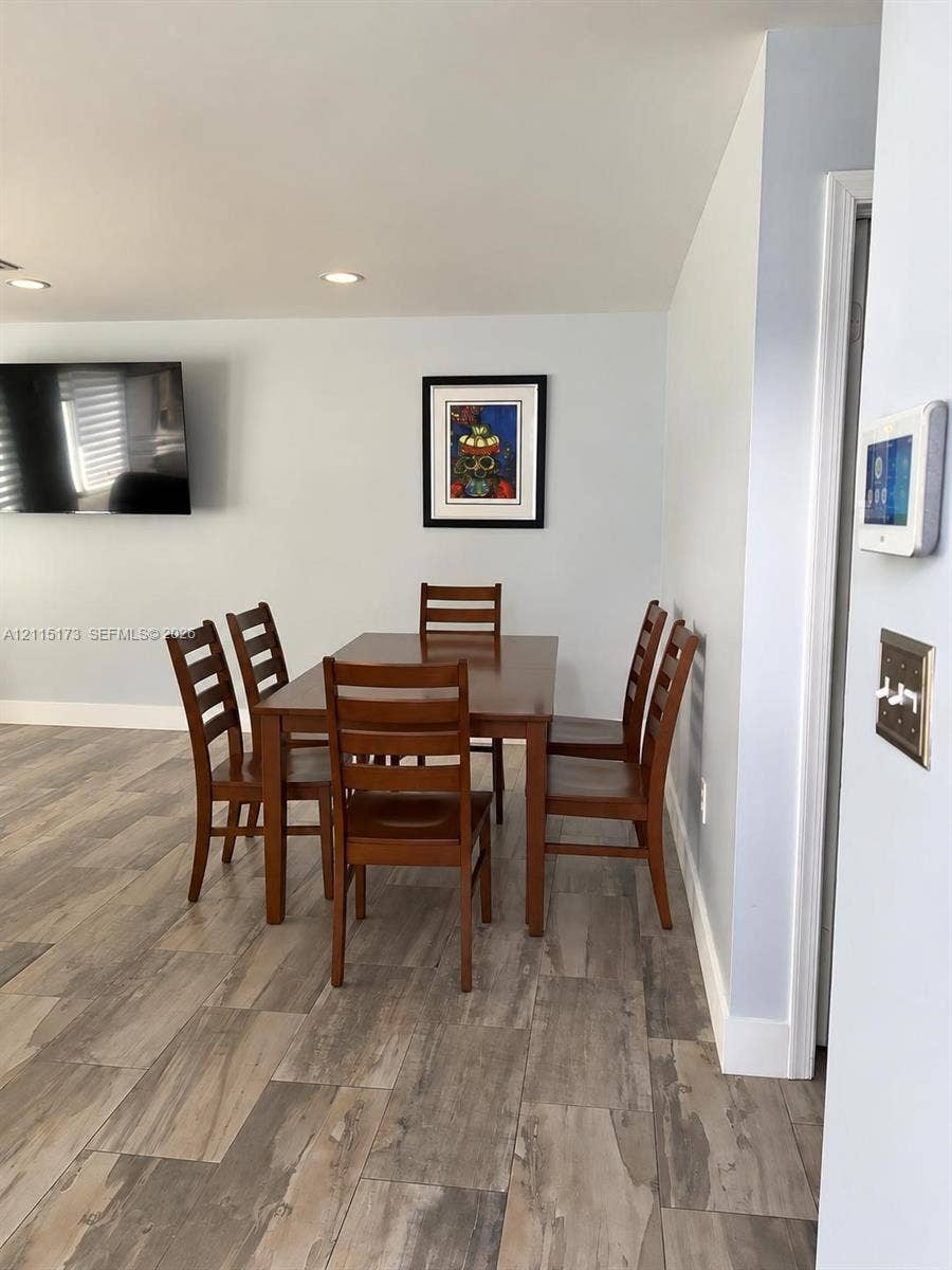 Wood-finish flooring, recessed lighting, and wall-mounted smart home control panel