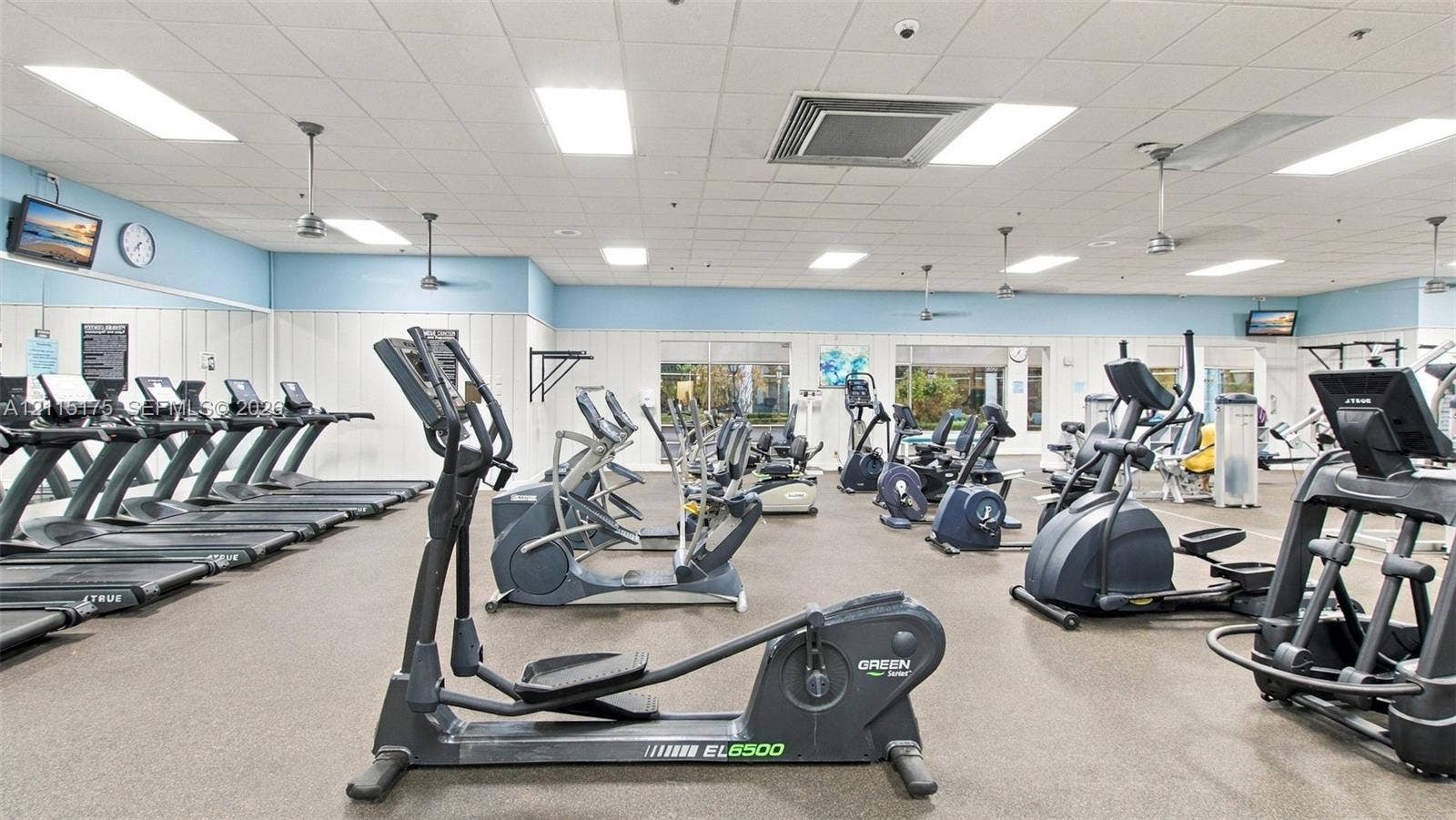 324 Seville N, Delray Beach, FL 33446 Fitness center featuring commercial-grade exercise equipment, mirrored wall panels, drop ceiling with recessed lighting, and resilient athletic flooring