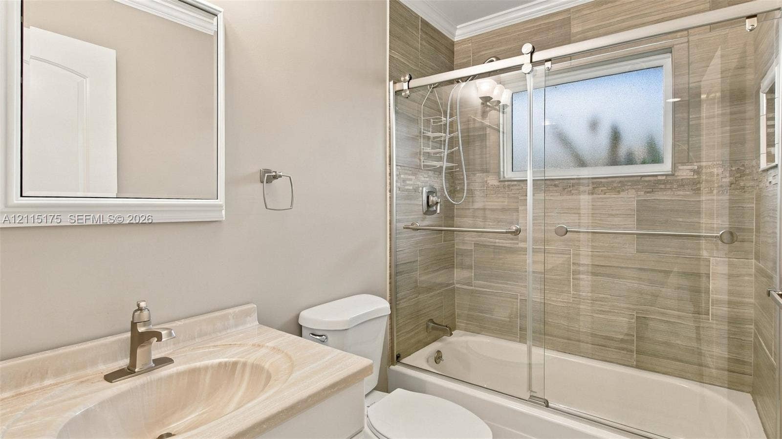 324 Seville N, Delray Beach, FL 33446 Guest bathroom featuring a tiled shower-tub combination enclosed by sliding glass doors