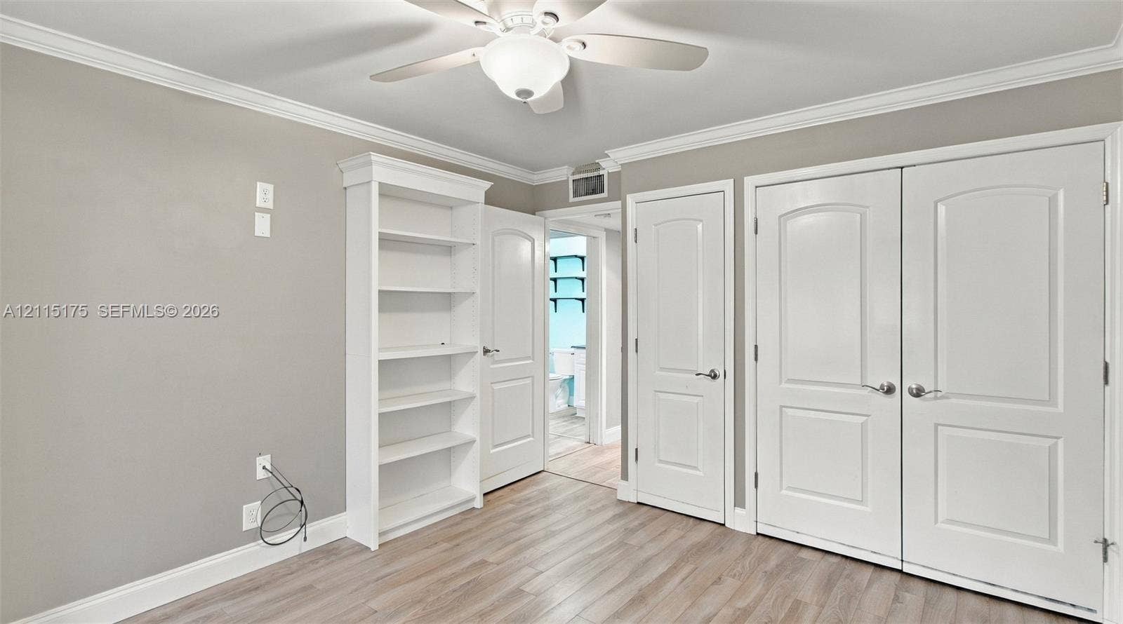 324 Seville N, Delray Beach, FL 33446 Second bedroom featuring wood-look laminate flooring, crown molding, multi-panel doors for closet, and a ceiling fan with integrated lighting