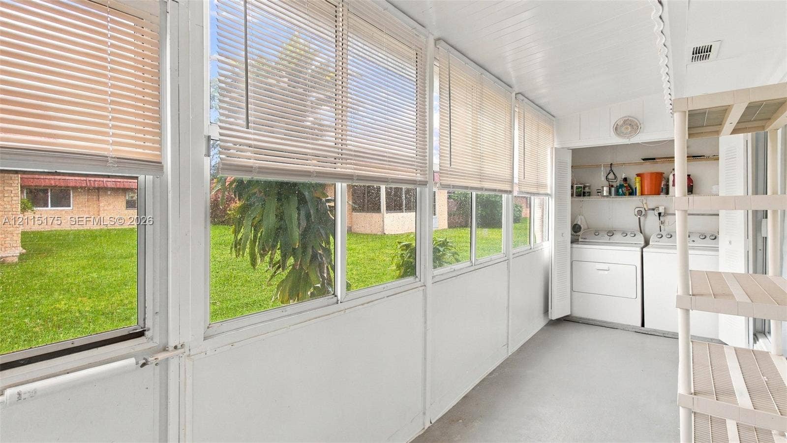 324 Seville N, Delray Beach, FL 33446 Enclosed lanai featuring expansive windows with horizontal blinds, beadboard ceiling, and integrated laundry area with closet storage