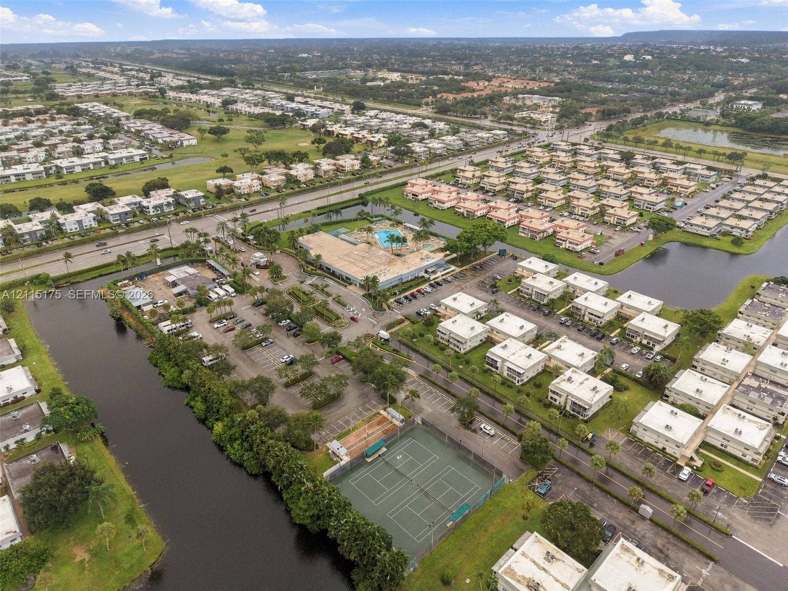 324 Seville N, Delray Beach, FL 33446 Aerial perspective of one of the satellite clubhouses with an outdoor swimming pool, as well as two clay tennis courts and a sport court