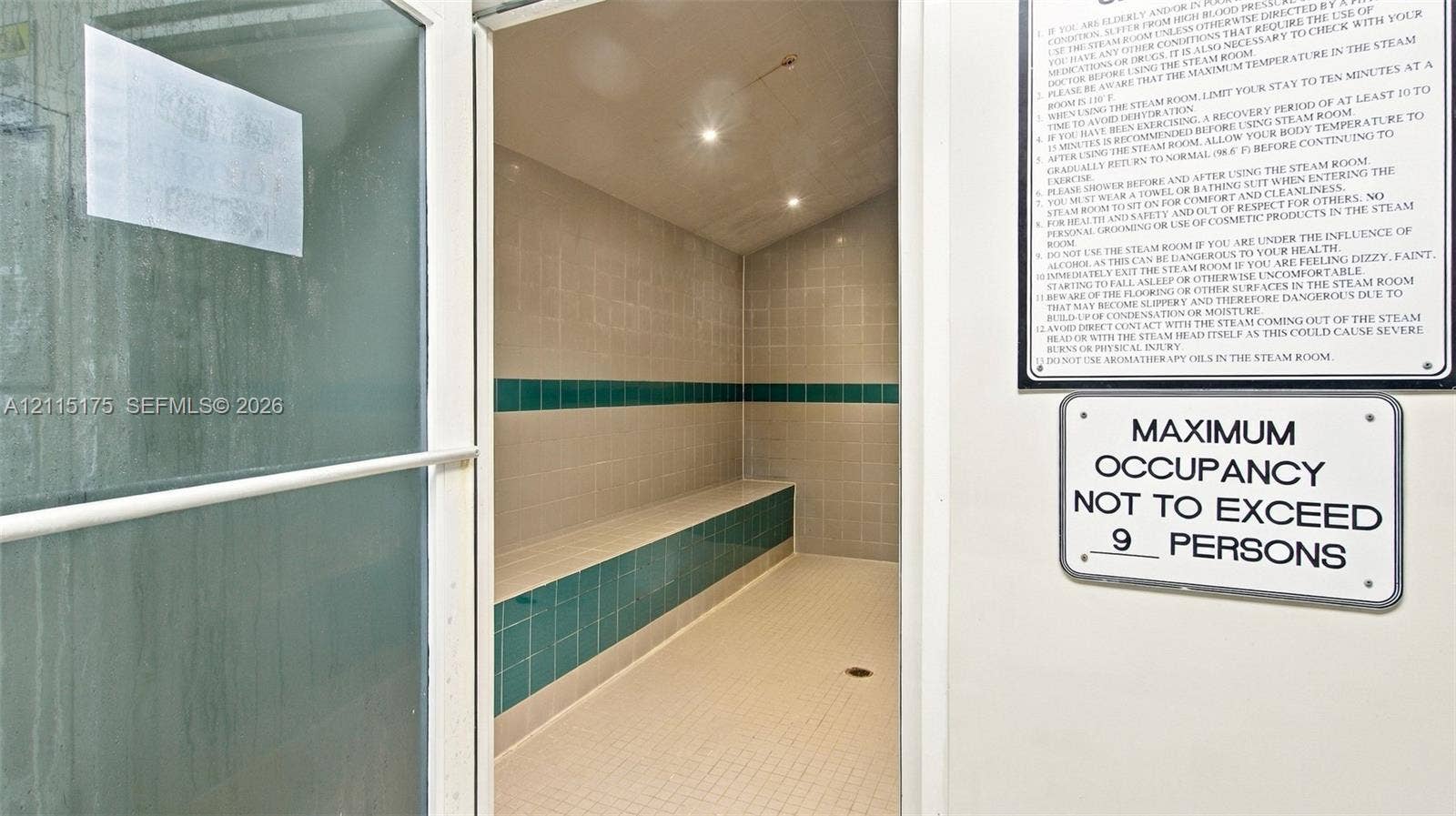 324 Seville N, Delray Beach, FL 33446 Steam room featuring tile flooring, built-in tiered seating, wall-mounted recessed lighting, and a glass-paneled entry door