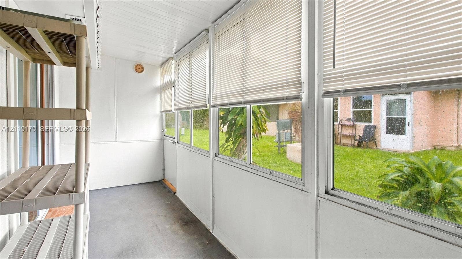 324 Seville N, Delray Beach, FL 33446 Enclosed lanai featuring expansive windows with horizontal blinds and neutral flooring