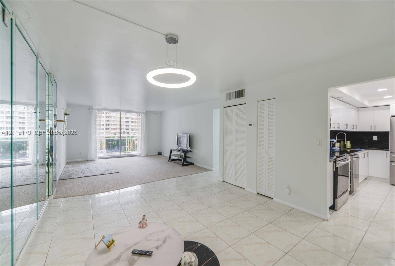 1849 S Ocean Drive, #407, Hallandale Beach, Hallandale Beach, FL 33009 Large-format tile flooring, circular pendant lighting, wall-to-wall mirrored panels, and bi-fold closet doors