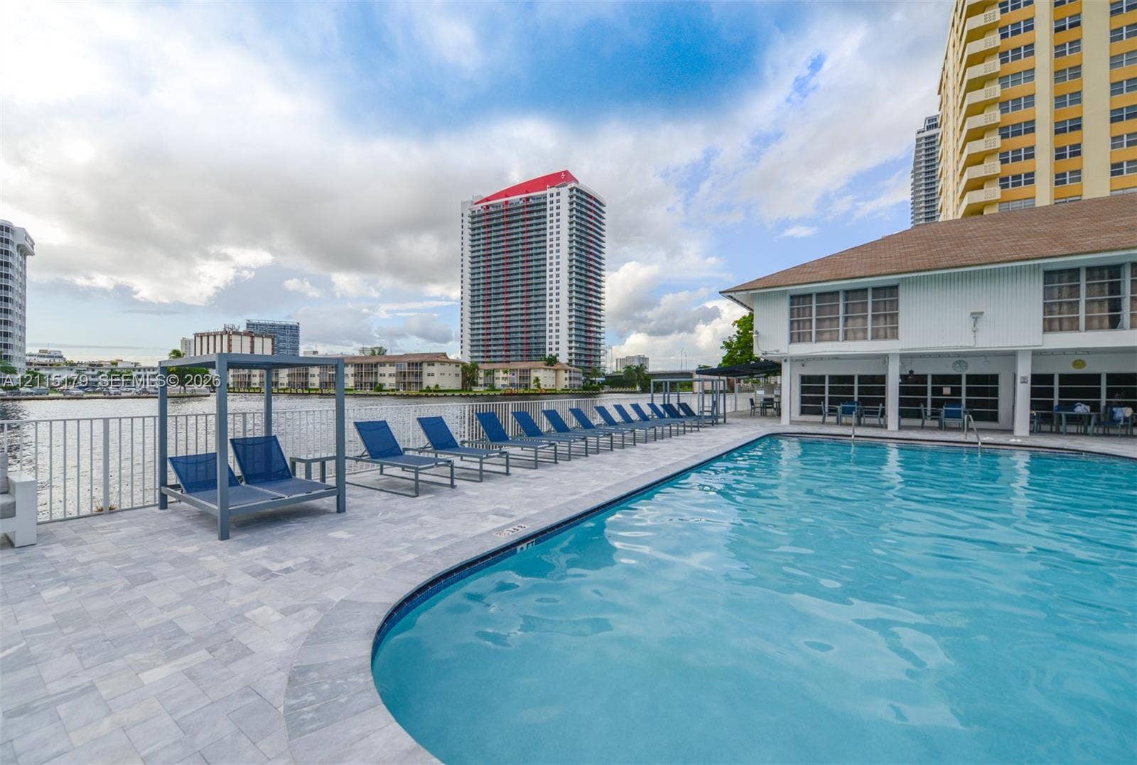 1849 S Ocean Drive, #407, Hallandale Beach, Hallandale Beach, FL 33009 Waterfront swimming pool featuring paver decking, metal perimeter fencing, and a built-in metal frame cabana structure