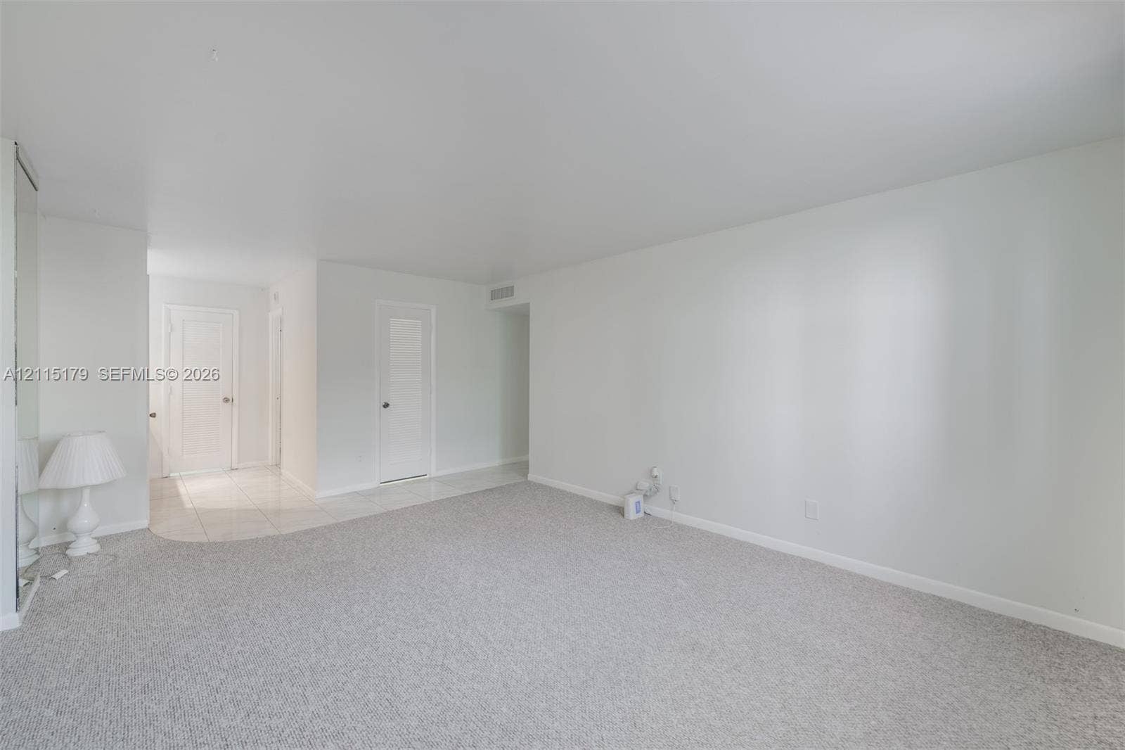 1849 S Ocean Drive, #407, Hallandale Beach, Hallandale Beach, FL 33009 Neutral interior featuring plush wall-to-wall carpeting, light-colored tile flooring, solid-core interior doors, and floor-to-ceiling mirrored closet doors