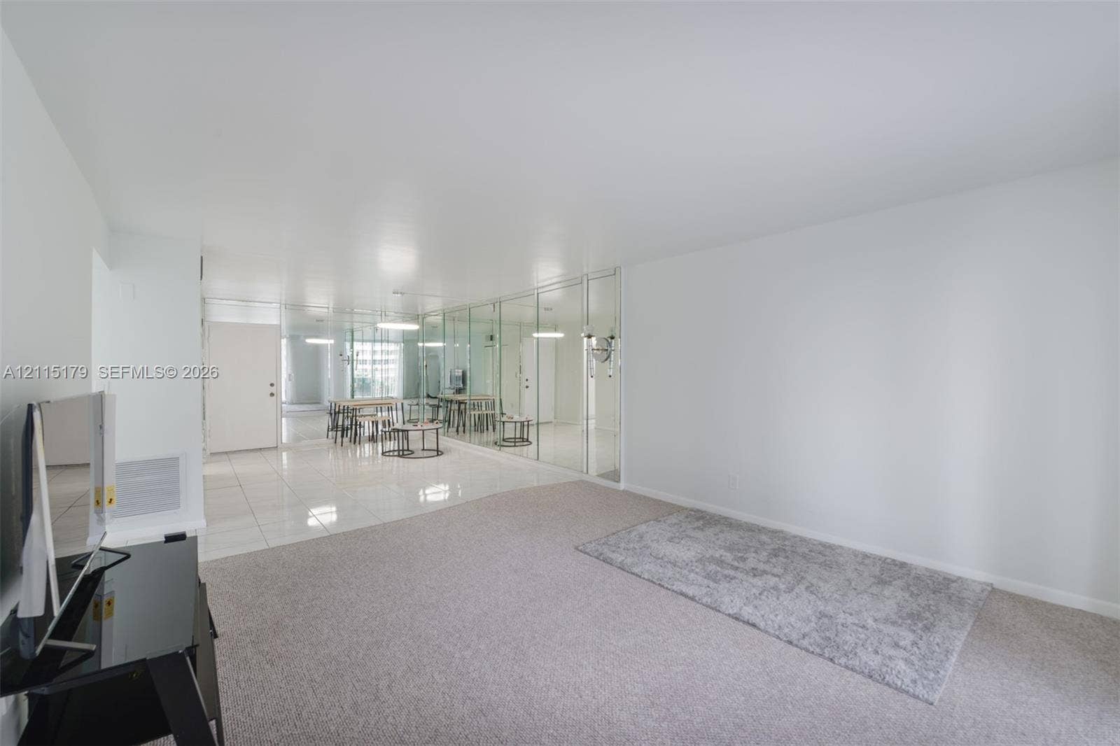1849 S Ocean Drive, #407, Hallandale Beach, Hallandale Beach, FL 33009 Open-concept interior featuring light-toned carpeting, glossy tile flooring, and wall-to-wall mirrored paneling