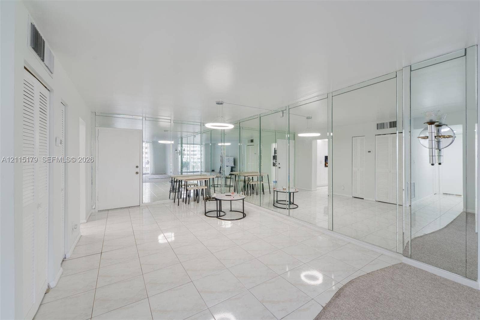 1849 S Ocean Drive, #407, Hallandale Beach, Hallandale Beach, FL 33009 Glossy tile flooring, wall-to-wall mirrored paneling, recessed circular lighting fixtures, and louvered-door closets