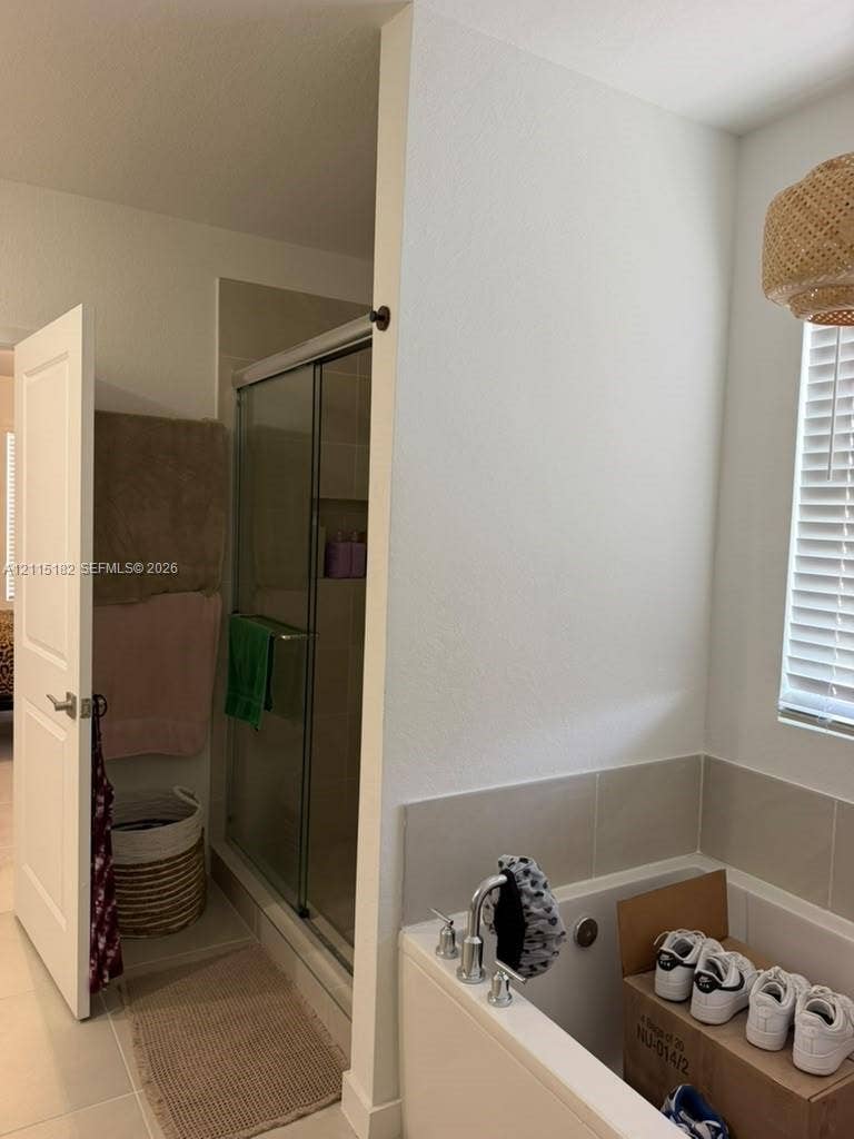 721 SE 17th Avenue, #721, Homestead, Homestead, FL 33033 Bathroom featuring a separate glass-enclosed shower, a deep soaking tub with tile surround, and a window with integrated blinds