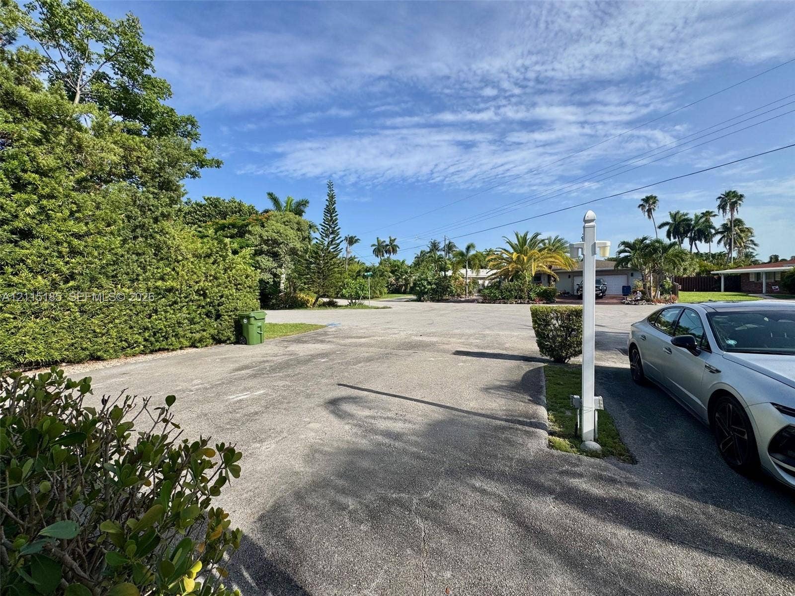 105-107 NE 30th Court, Wilton Manors, FL 33334 Asphalt surface driveway featuring mature landscaping and palm trees
