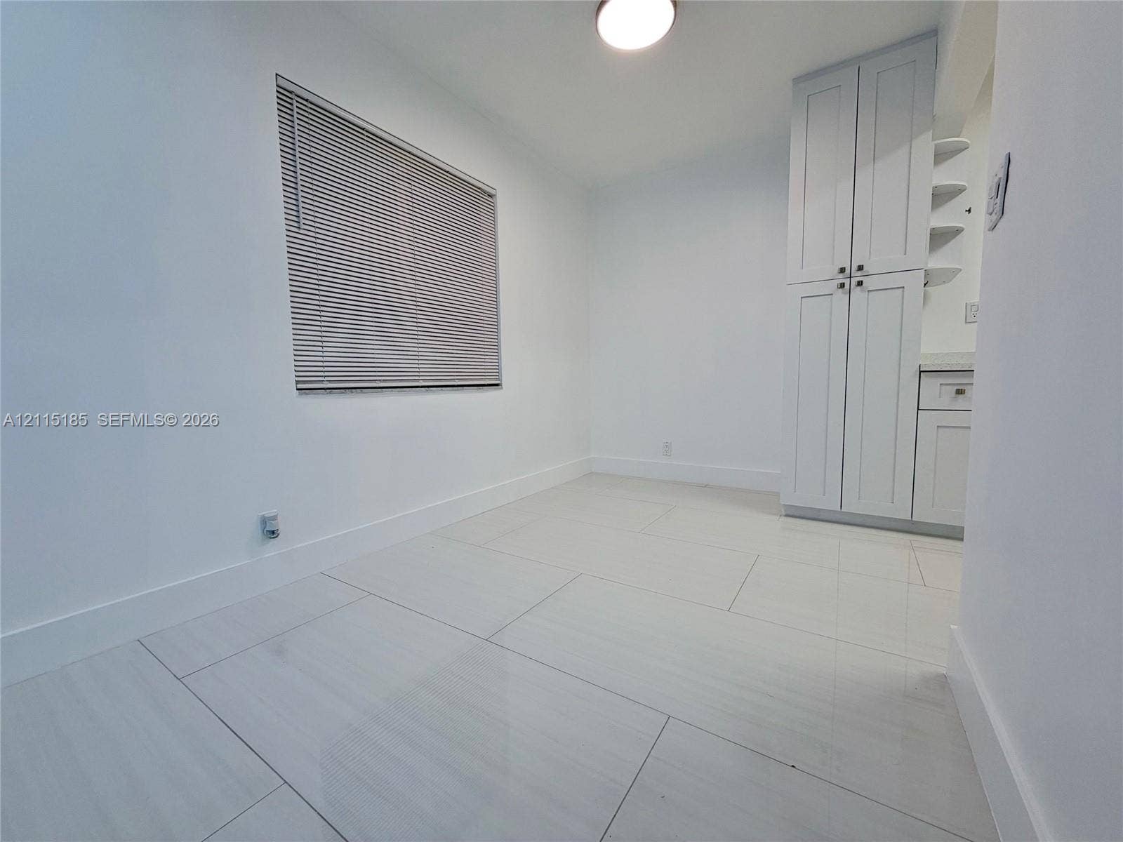 105-107 NE 30th Court, Wilton Manors, FL 33334 Large-format tile flooring, built-in floor-to-ceiling cabinetry with shaker-style doors, and recessed ceiling lighting