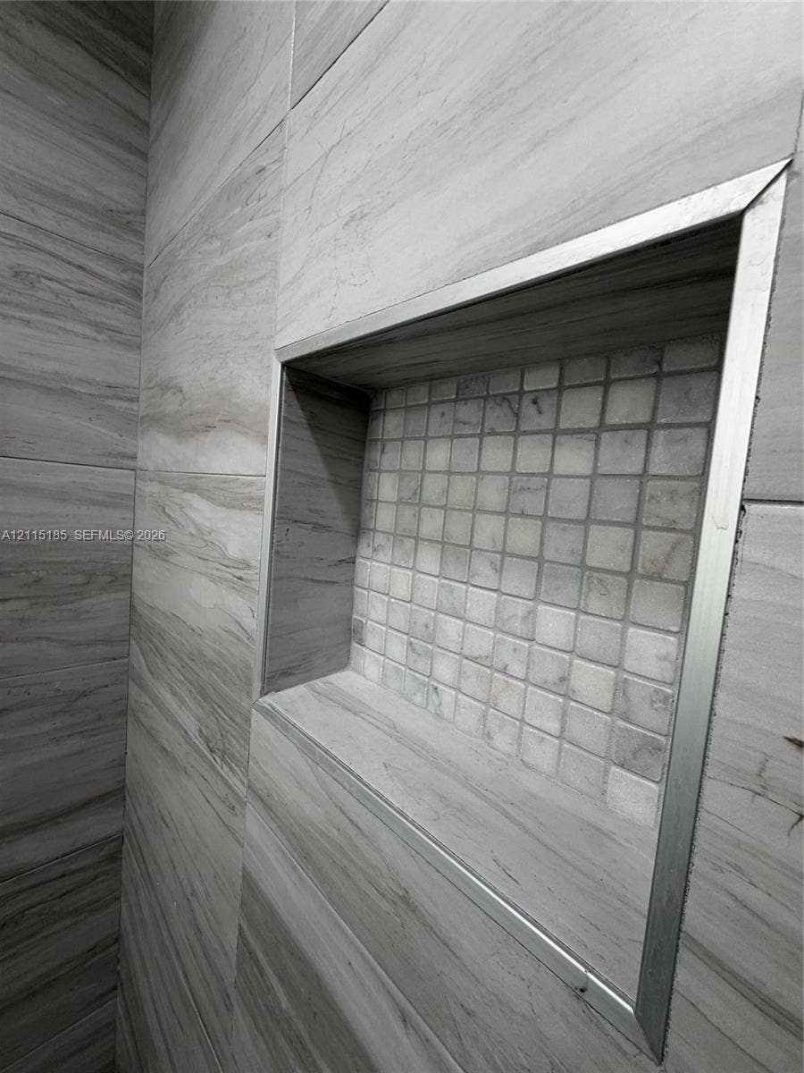 105-107 NE 30th Court, Wilton Manors, FL 33334 Recessed shower niche featuring large-format horizontal tile, square mosaic tile inlay, and brushed metal trim