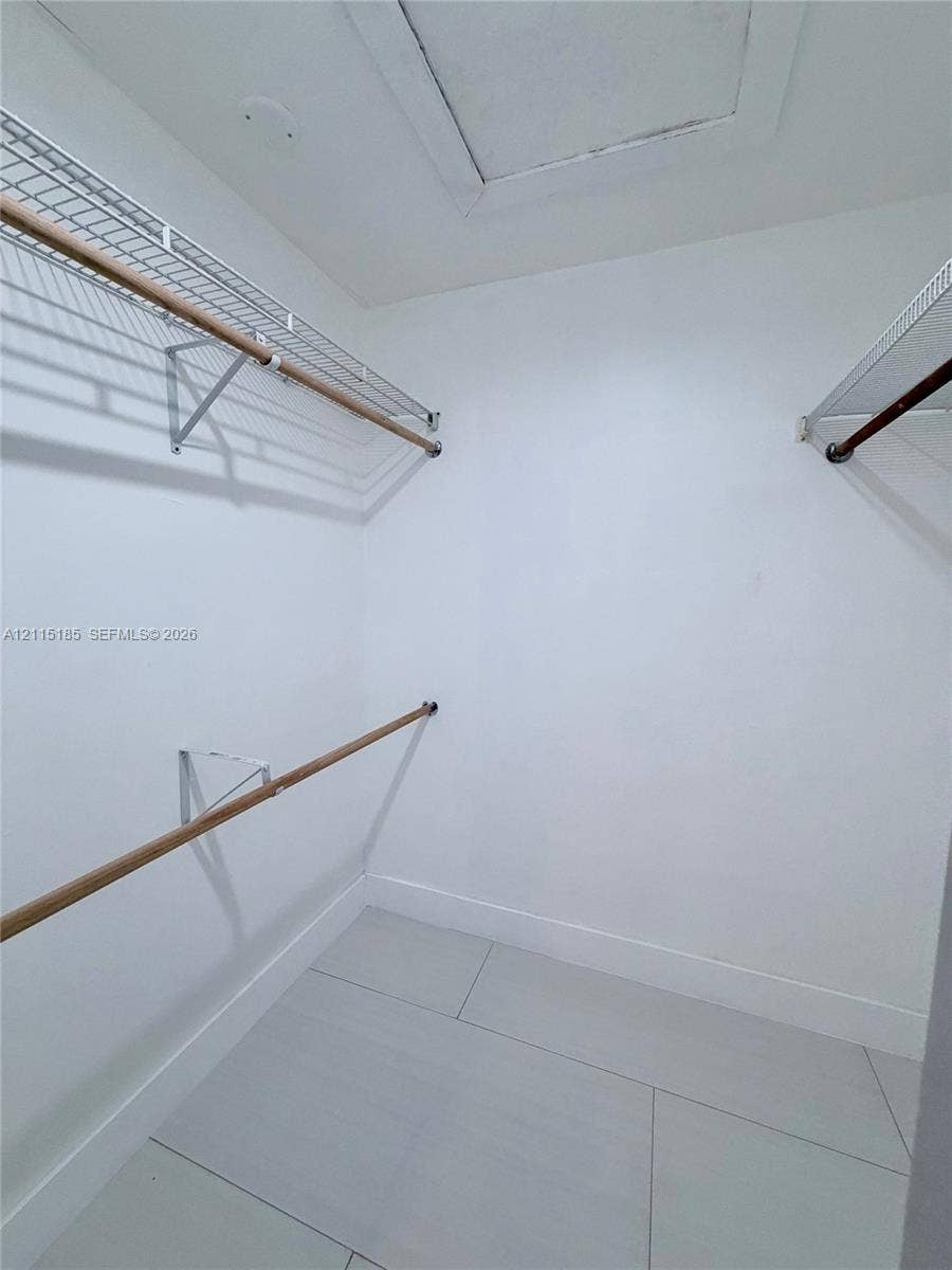 105-107 NE 30th Court, Wilton Manors, FL 33334 Walk-in closet featuring large-format tile flooring and tiered wire shelving with wood-finish rods