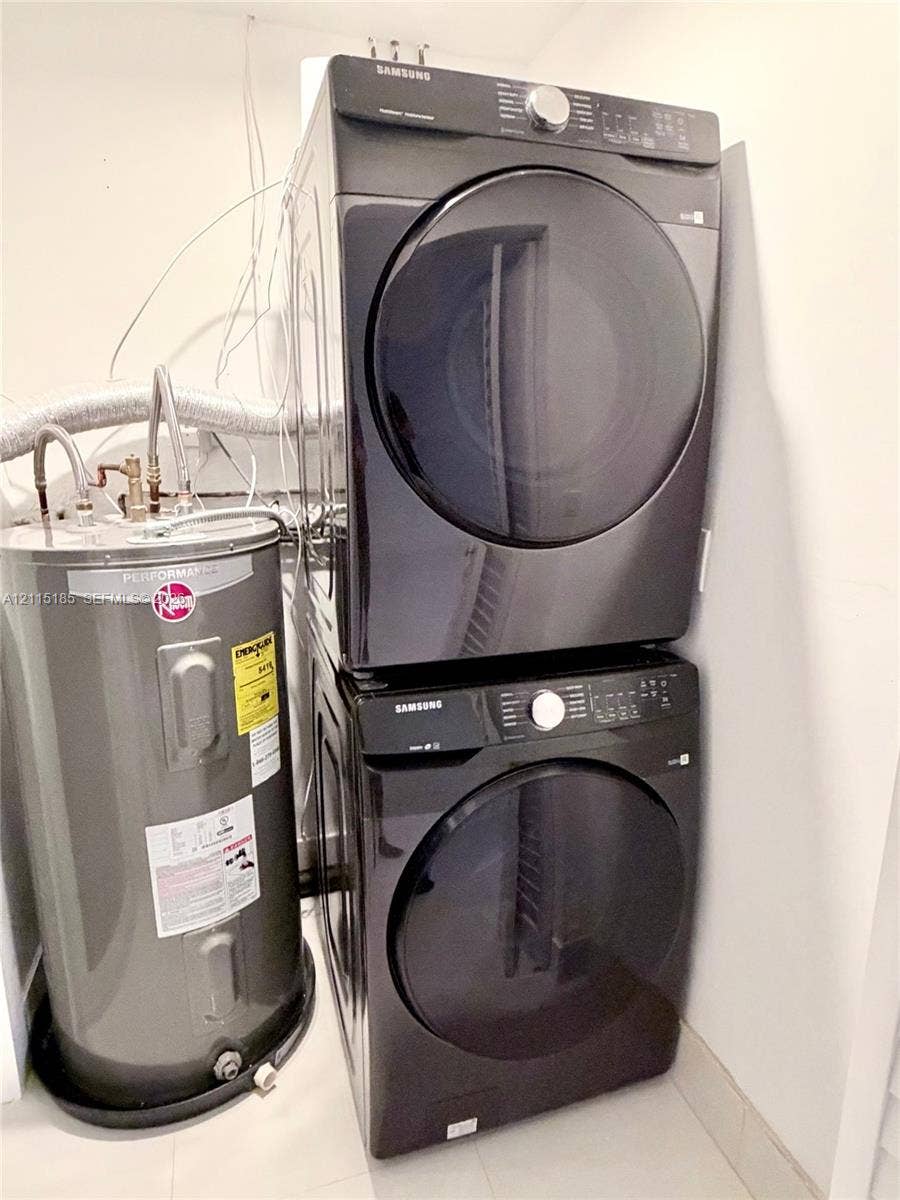 105-107 NE 30th Court, Wilton Manors, FL 33334 Stacked dark-finish front-load laundry appliances and a cylindrical water heater