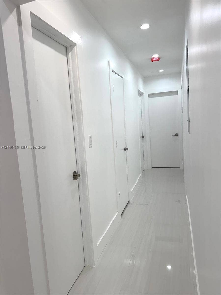 105-107 NE 30th Court, Wilton Manors, FL 33334 Hallway featuring polished tile flooring, smooth-finish walls, and recessed ceiling lighting