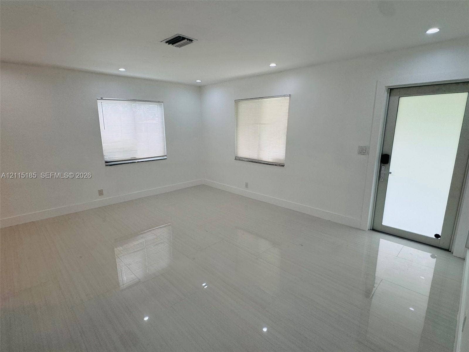 105-107 NE 30th Court, Wilton Manors, FL 33334 Neutral-toned space featuring polished tile flooring, recessed ceiling lighting, and a glass-paneled exterior door